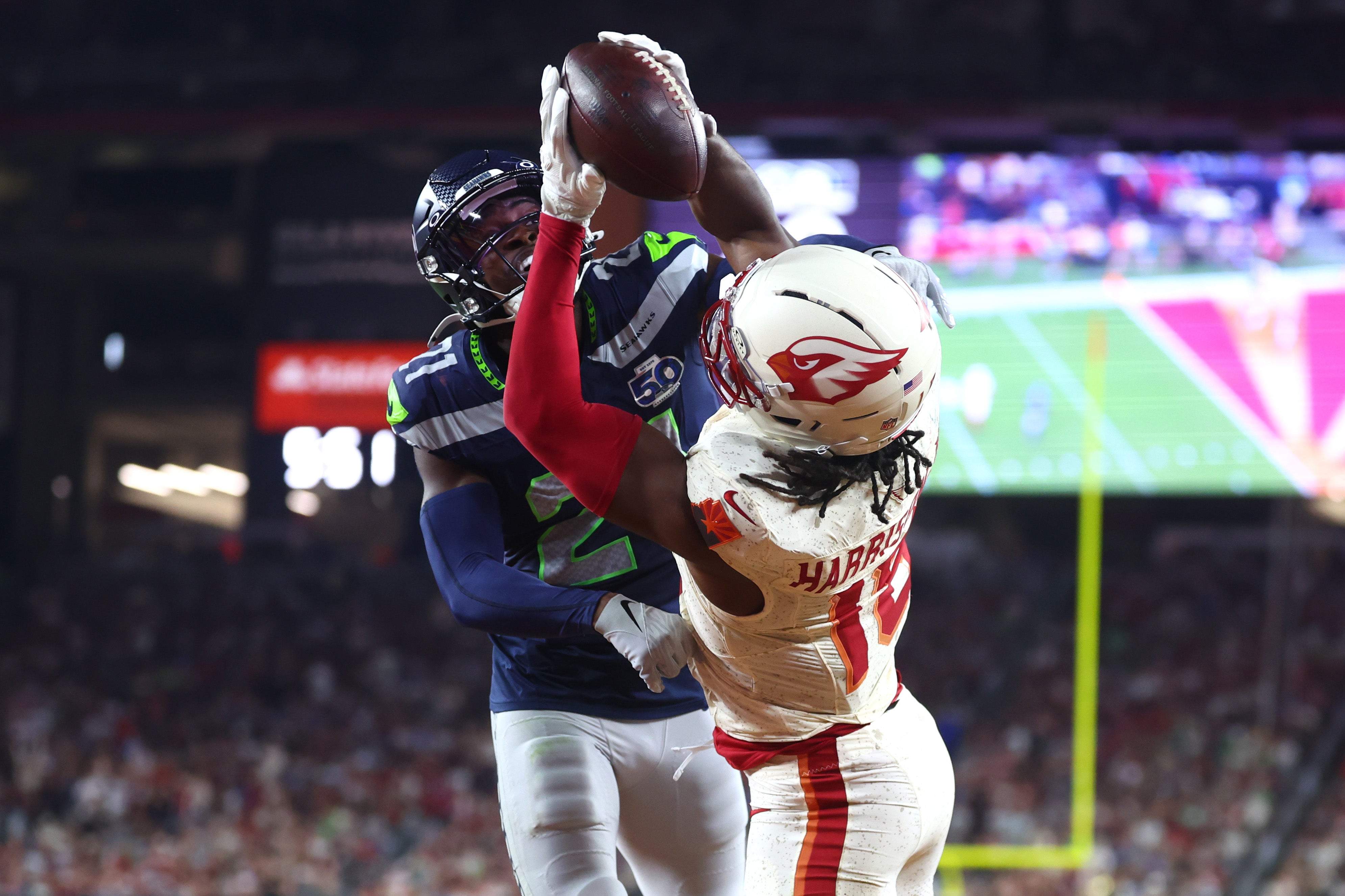 Sep 25, 2025; Glendale, Arizona, USA; Arizona Cardinals wide receiver Marvin Harrison Jr. (18) makes a catch for a touchdown against Seattle Seahawks cornerback Devon Witherspoon (21) in the fourth quarter at State Farm Stadium.