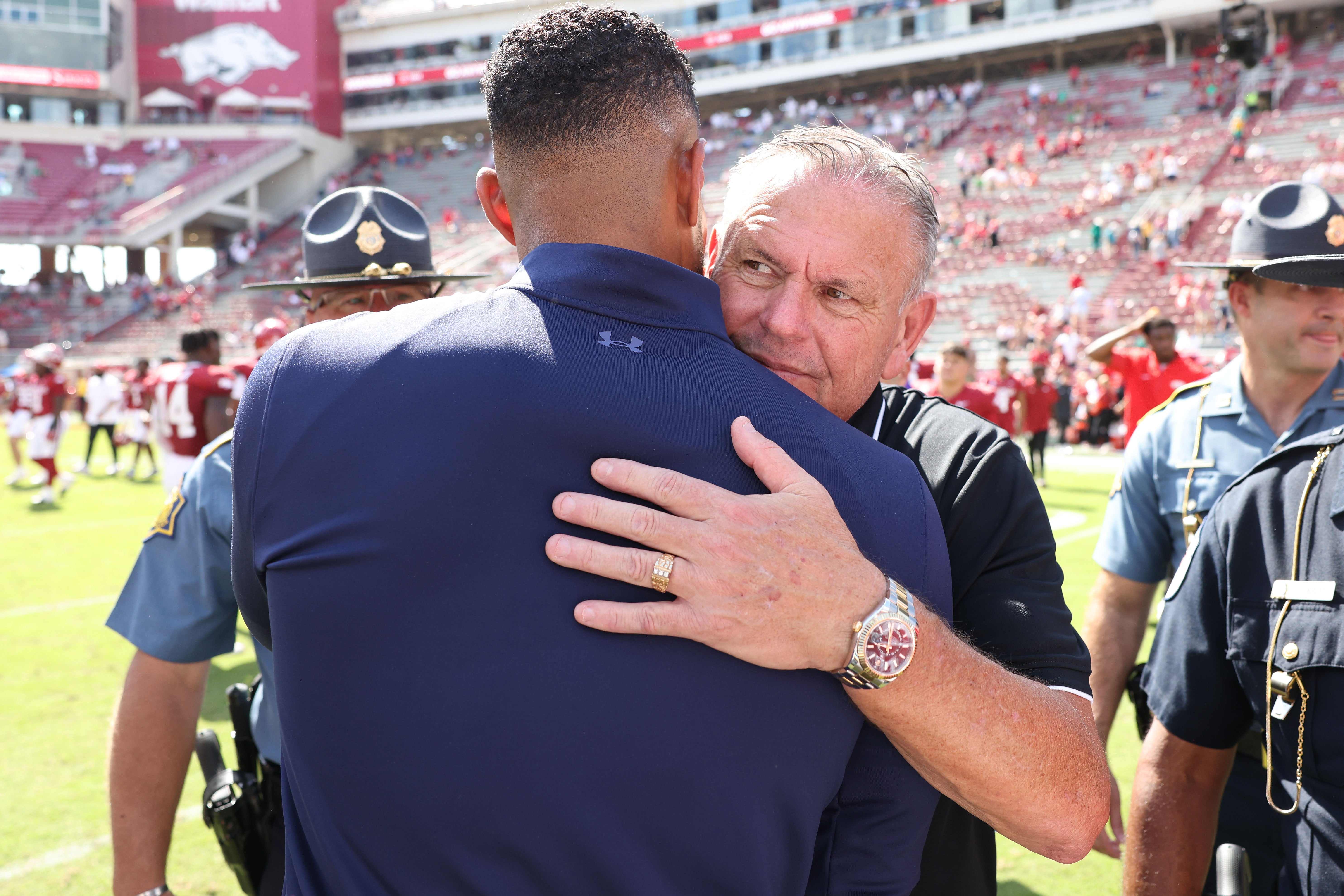 Sep 27, 2025; Fayetteville, Arkansas, USA; Notre Dame Fighting Irish head coach Marcus Freeman hugs Arkansas Razorbacks head coach Sam Pittman after the game at Donald W. Reynolds Razorback Stadium. Notre Dame won 56-13. Mandatory Credit: Nelson Chenault-Imagn Images