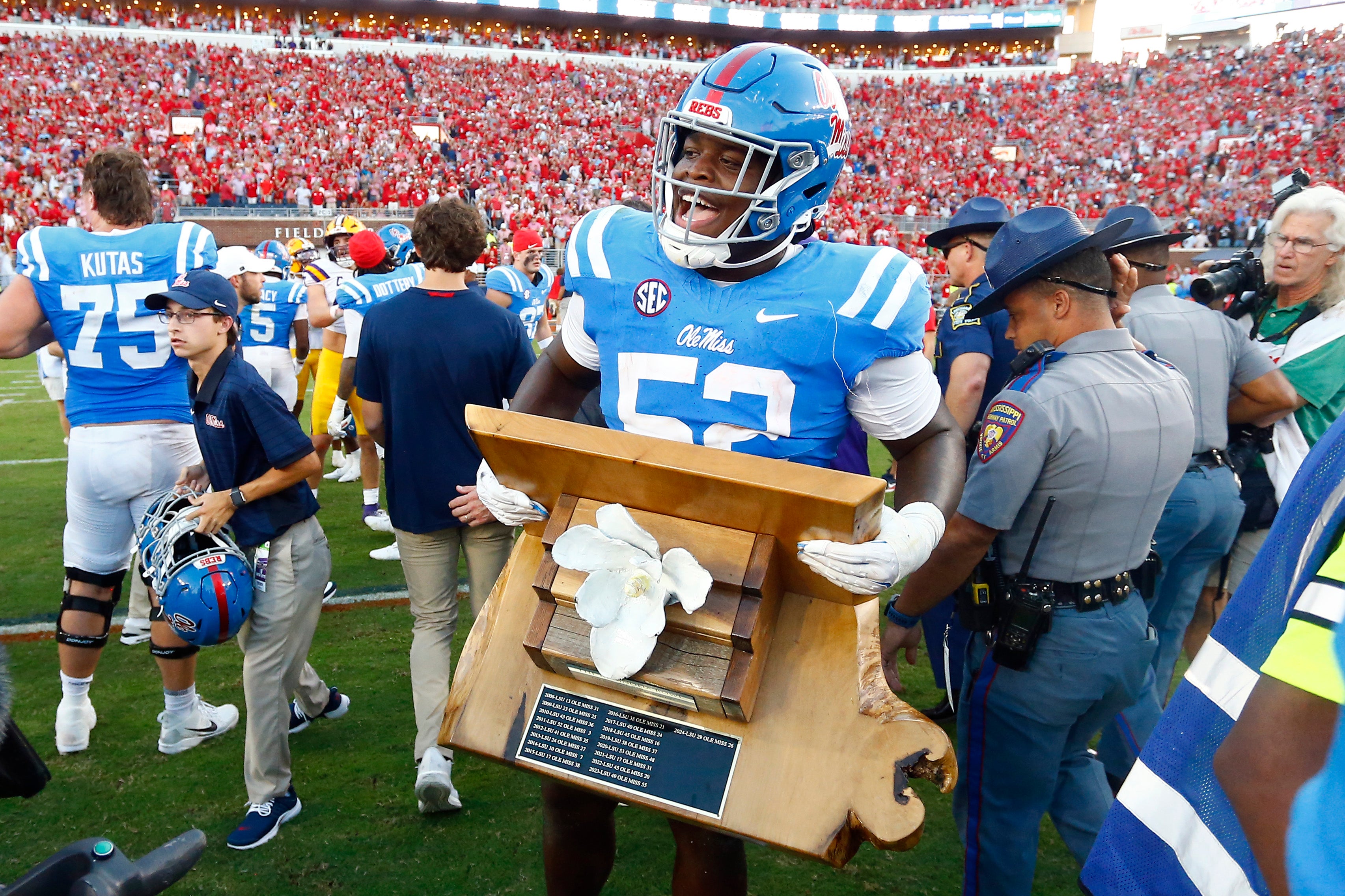 Sep 27, 2025; Oxford, Mississippi, USA; Mississippi Rebels offensive lineman Cooper Johnson (52) carries the Magnolia Bowl trophy after defeating the LSU Tigers at Vaught-Hemingway Stadium.