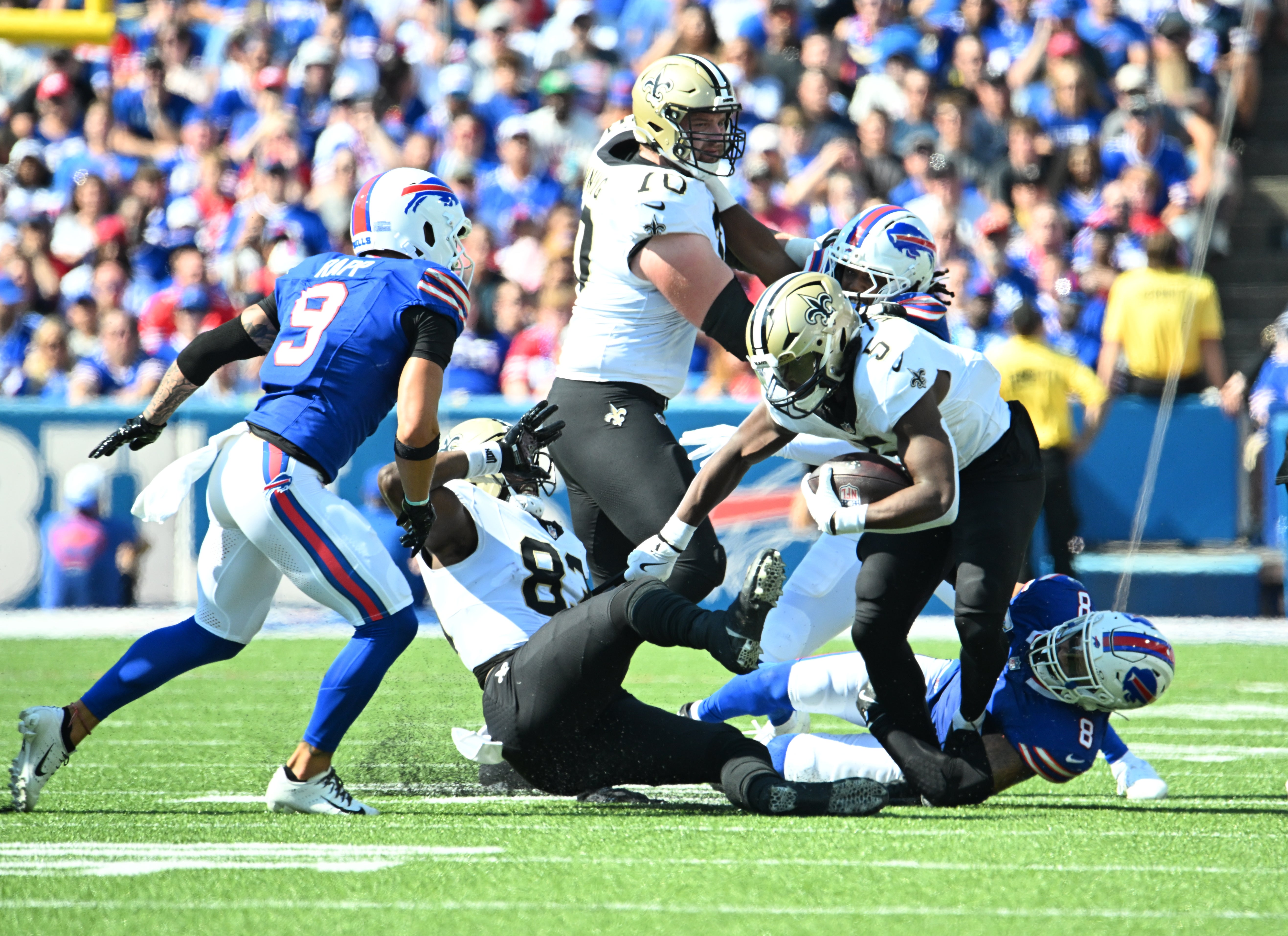 Sep 28, 2025; Orchard Park, New York, USA; New Orleans Saints running back Kendre Miller (5) runs for a gain past Buffalo Bills linebacker Terrel Bernard (8) during the second quarter at Highmark Stadium.