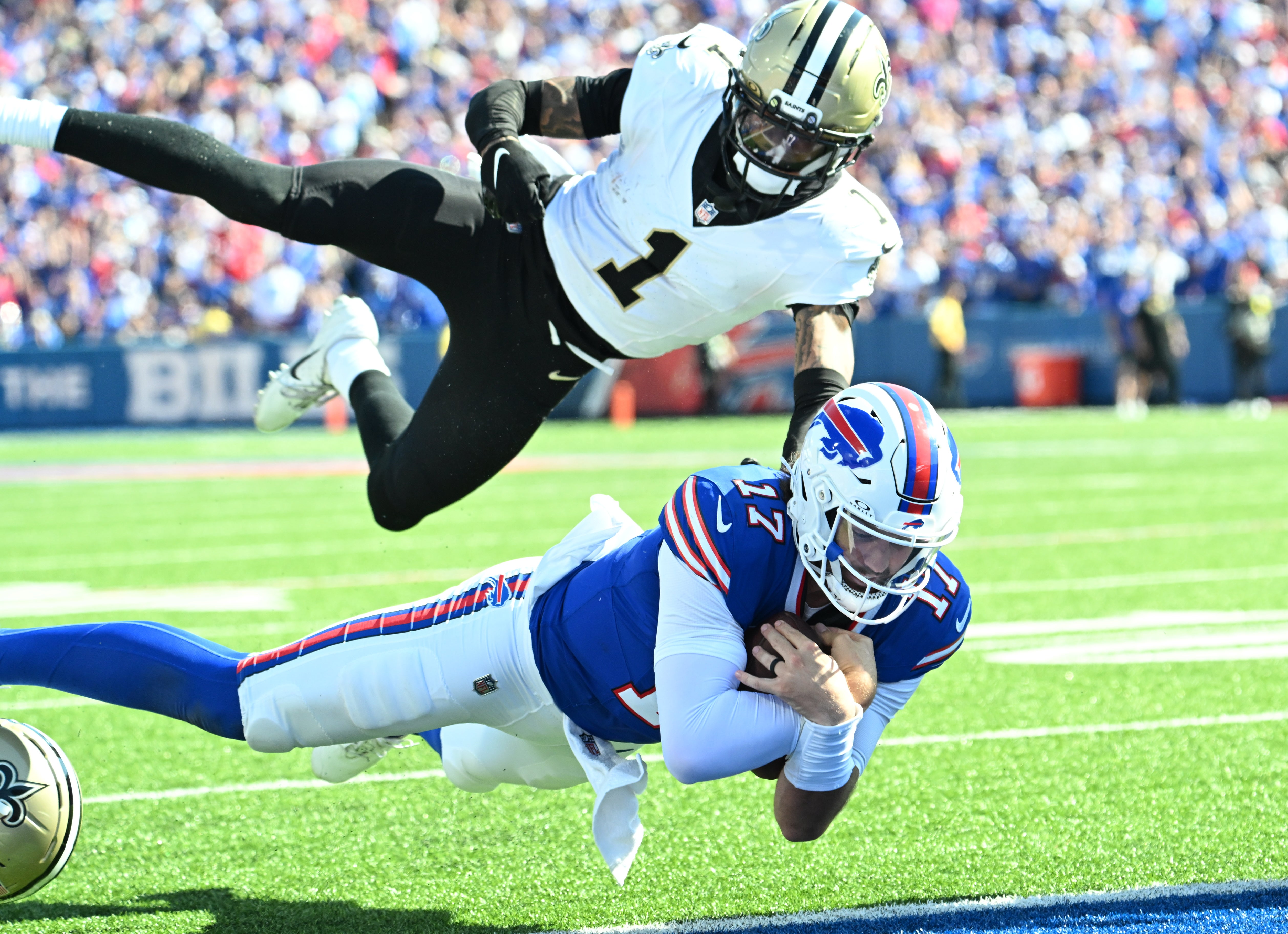 Sep 28, 2025; Orchard Park, New York, USA; Buffalo Bills quarterback Josh Allen (17) dives for a touchdown past New Orleans Saints cornerback Alontae Taylor (1) during the third quarter at Highmark Stadium.