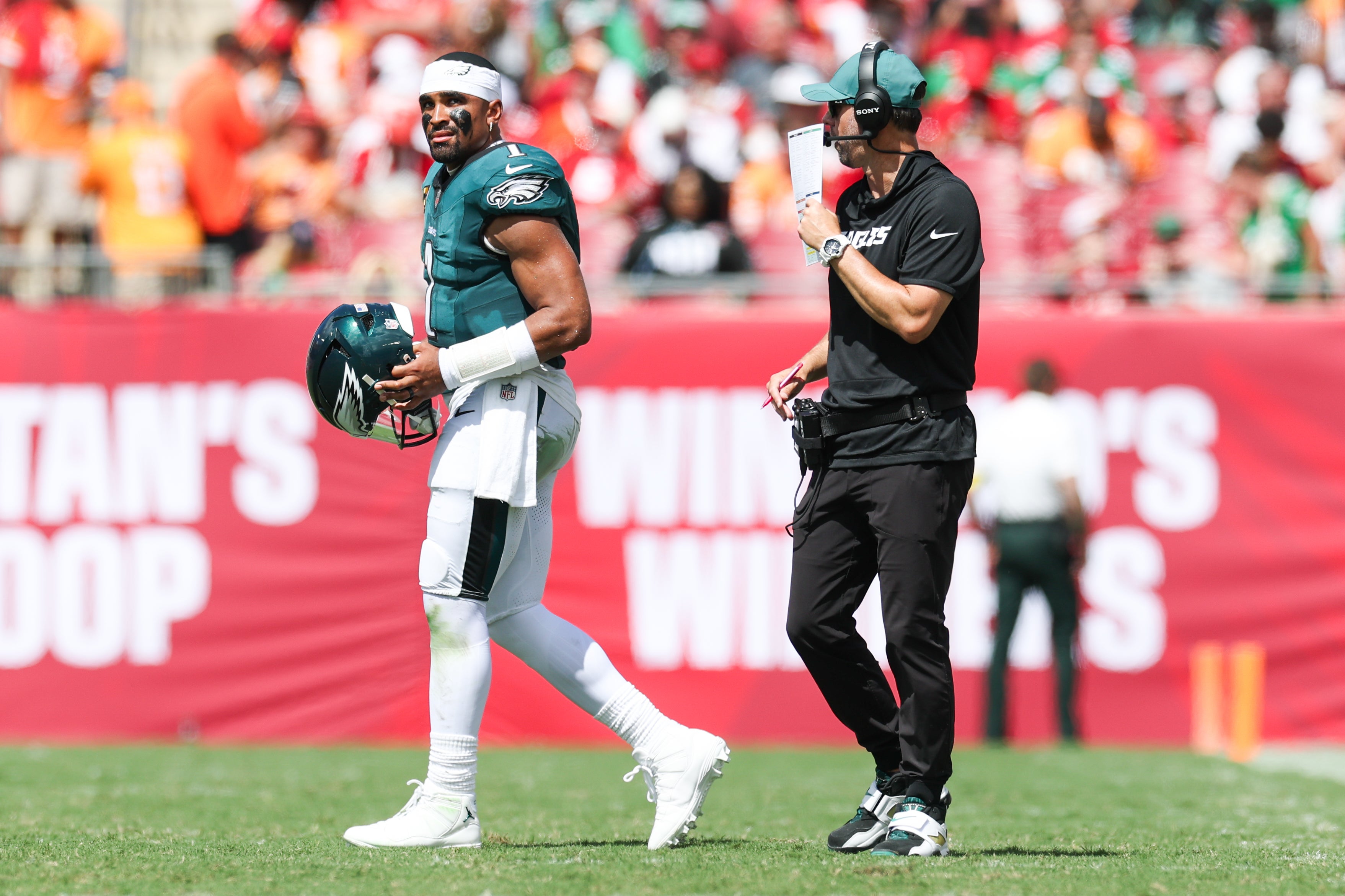 Philadelphia Eagles offensive coach Kevin Patullo communicates with quarterback Jalen Hurts (1) during a timeout in the second quarter against the Tampa Bay Buccaneers at Raymond.