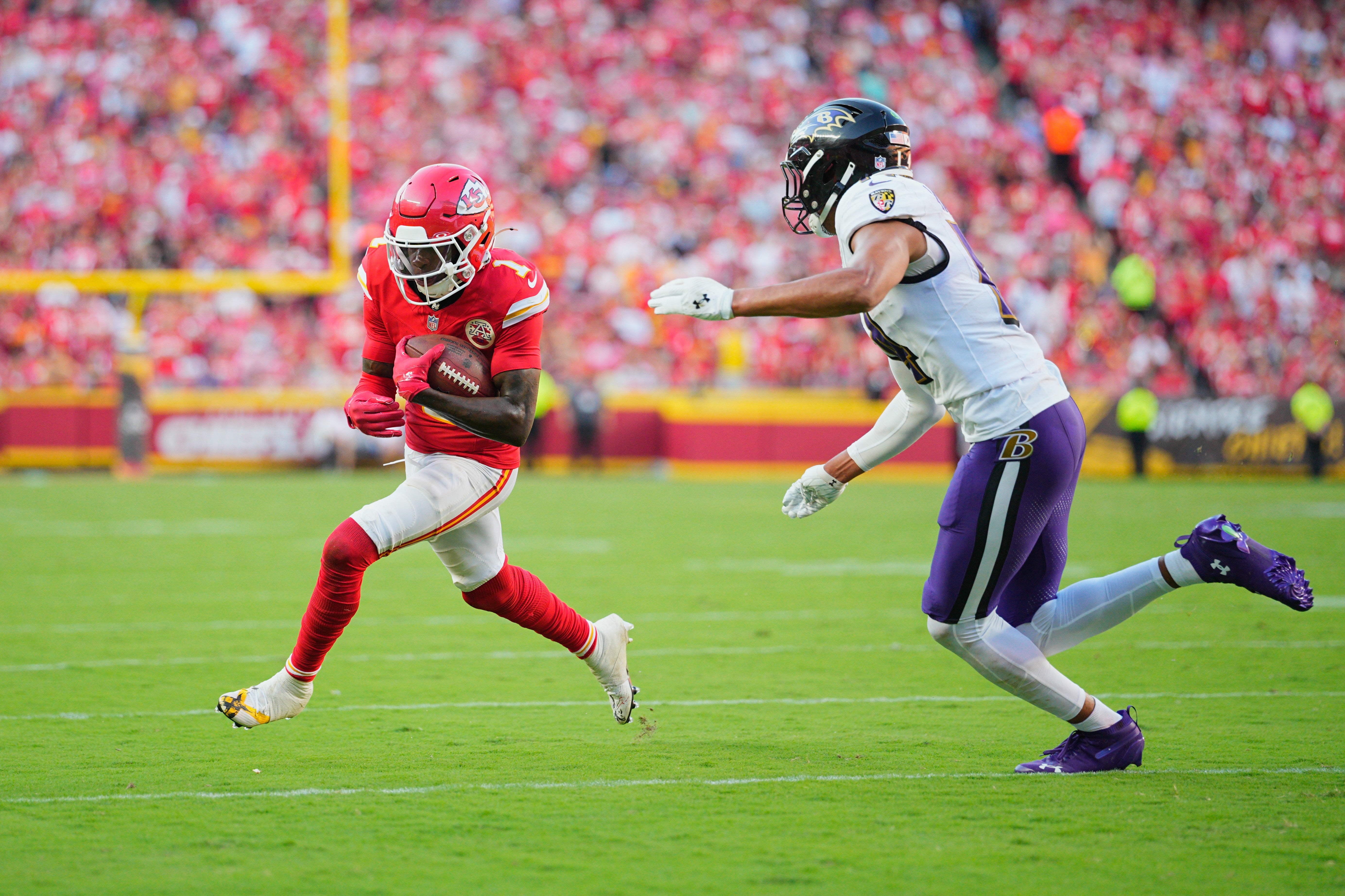 Kansas City Chiefs wide receiver Xavier Worthy (1) runs after making a catch as Baltimore Ravens cornerback Marlon Humphrey (44) defends during the third quarter at GEHA Field at Arrowhead Stadium.