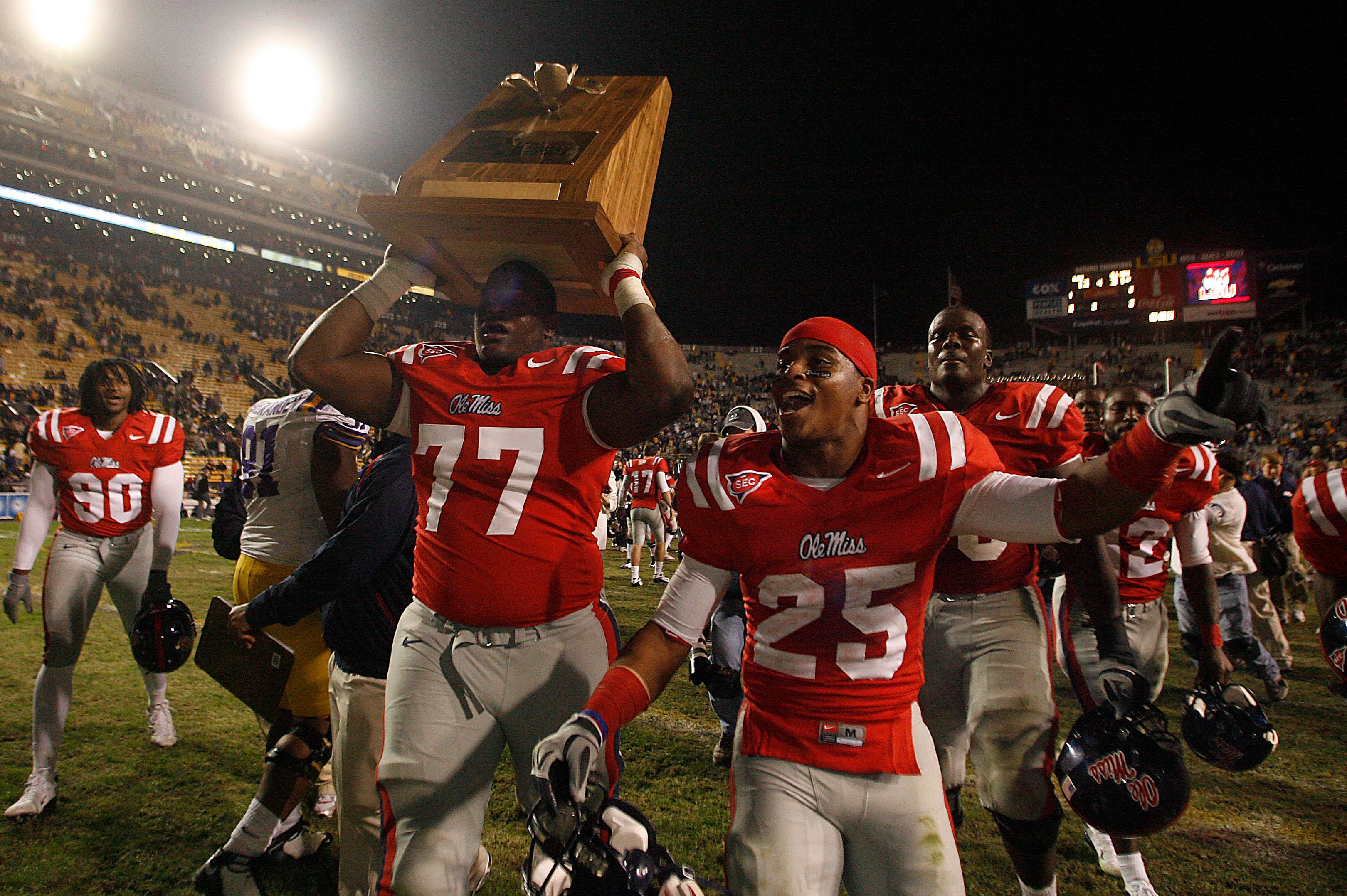 November 22, 2008; Baton Rouge, LA, USA; Mississippi Rebels offensive lineman John Jerry (77) holds up the Magnolia Bowl trophy as teammate Cordera Eason (25) celebrates following the Rebels 31-13 victory against the LSU Tigers at Tiger Stadium. Mandatory Credit: Crystal LoGiudice-USA TODAY Sports