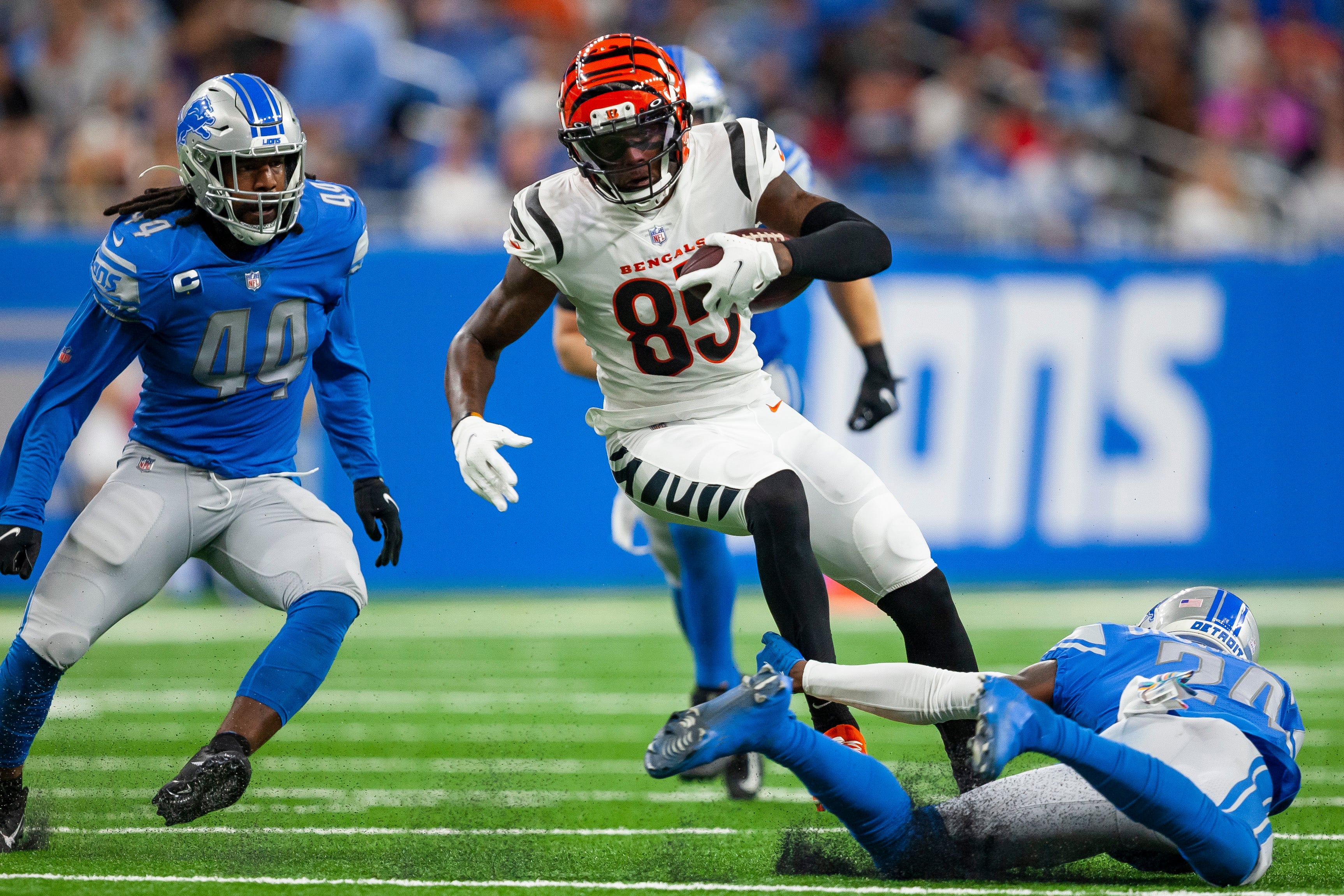 Oct 17, 2021; Detroit, Michigan, USA; Cincinnati Bengals wide receiver Tee Higgins (85) gets tripped up by Detroit Lions cornerback Amani Oruwariye (24) during the third quarter at Ford Field.