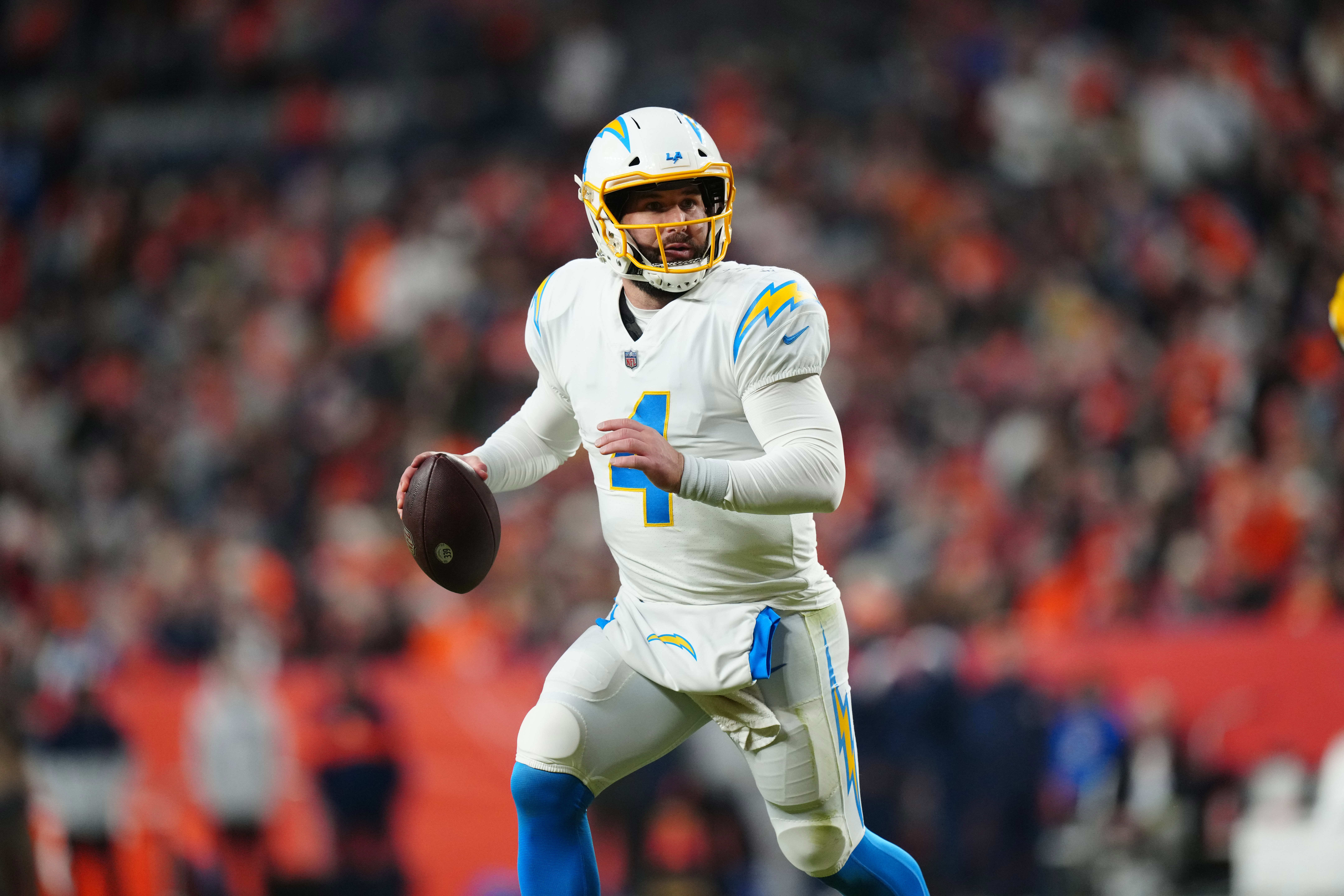 Jan 8, 2023; Denver, Colorado, USA; Los Angeles Chargers quarterback Chase Daniel (4) scrambles in the fourth quarter against the Denver Broncos at Empower Field at Mile High. Mandatory Credit: Ron Chenoy-USA TODAY Sports