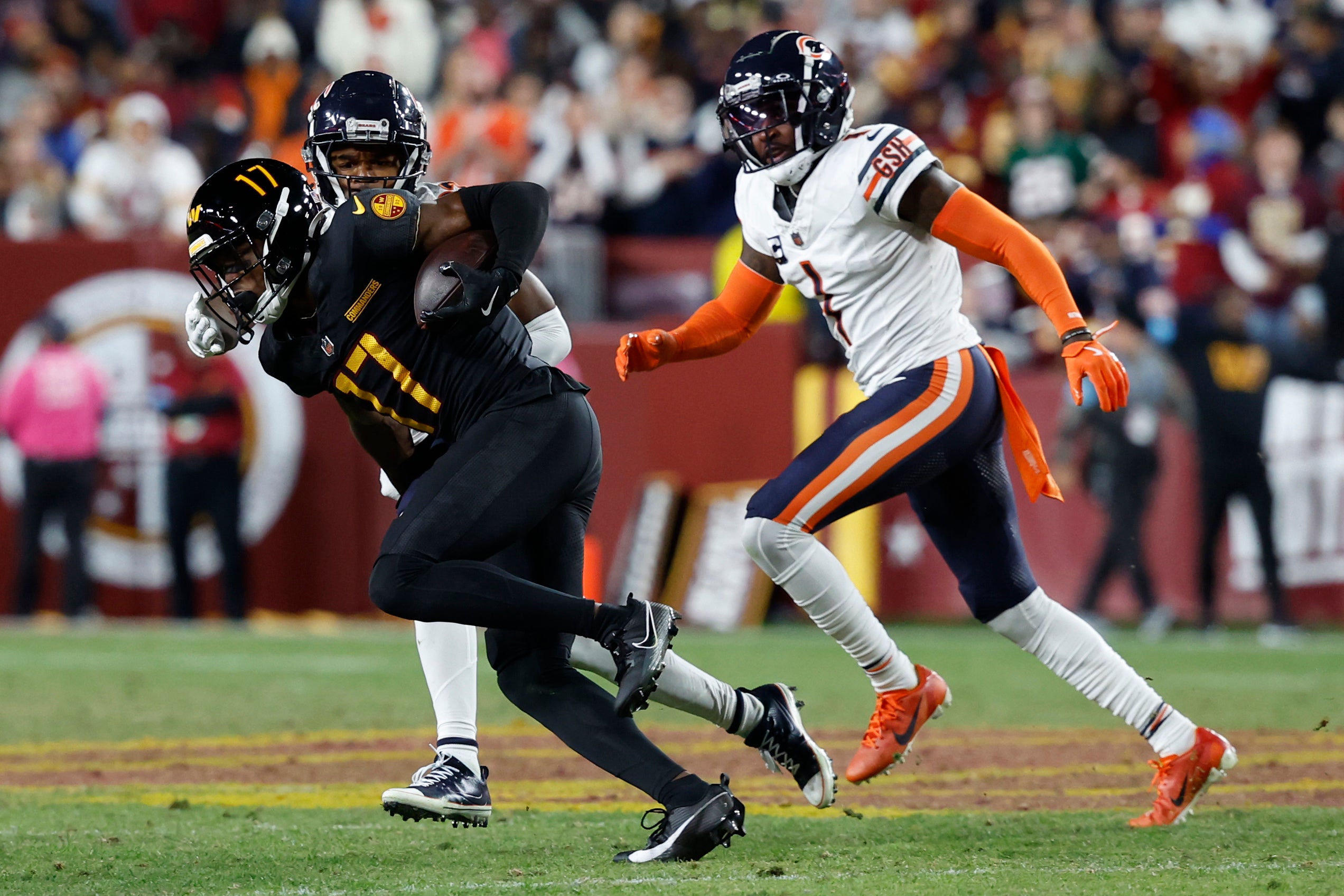 Oct 27, 2024; Landover, Maryland, USA; Washington Commanders wide receiver Terry McLaurin (17) runs with the ball past Chicago Bears cornerback Jaylon Johnson (1) during the third quarter at Northwest Stadium.