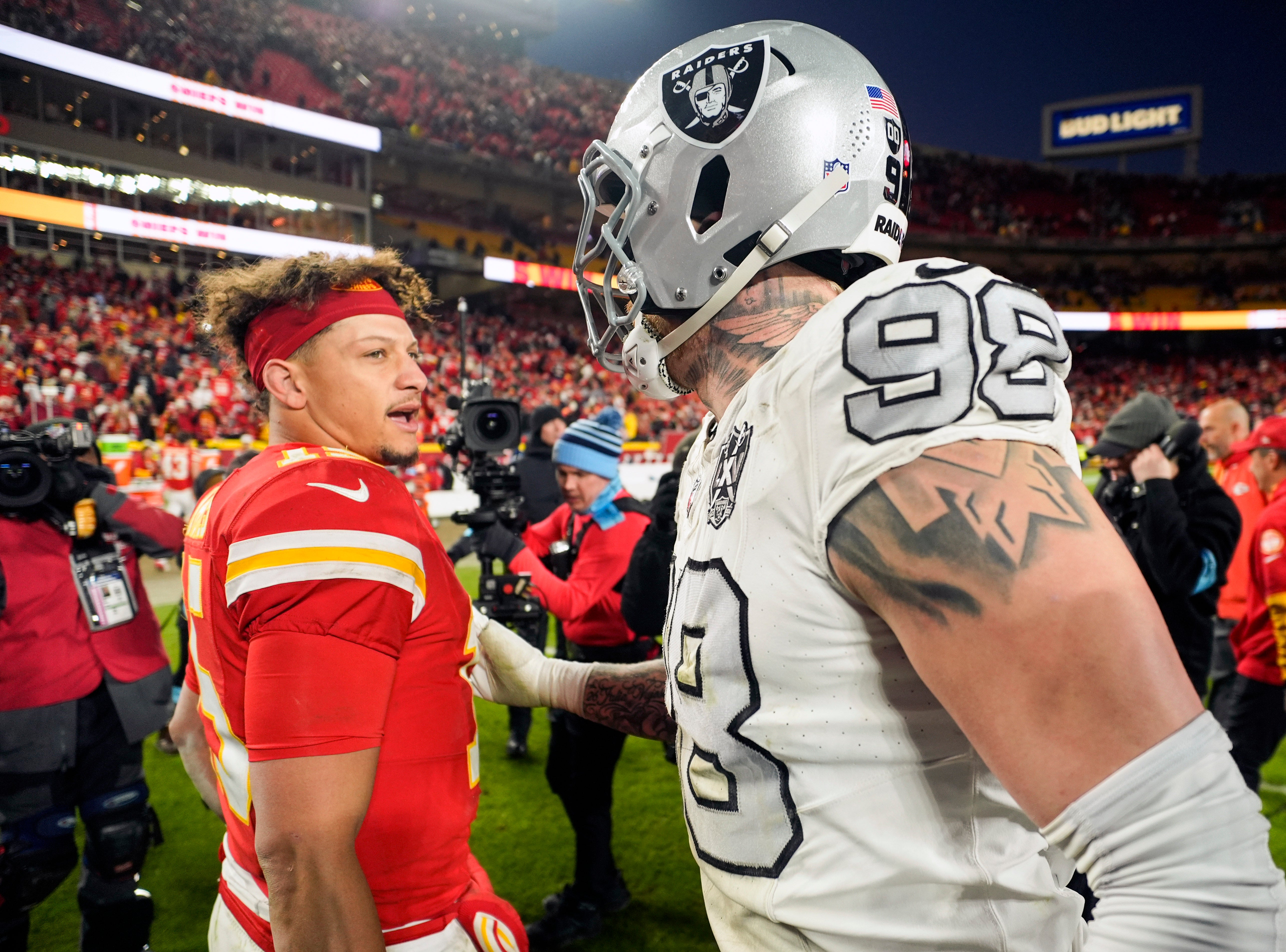 Kansas City Chiefs quarterback Patrick Mahomes (15) talks with Las Vegas Raiders defensive end Maxx Crosby (98)
