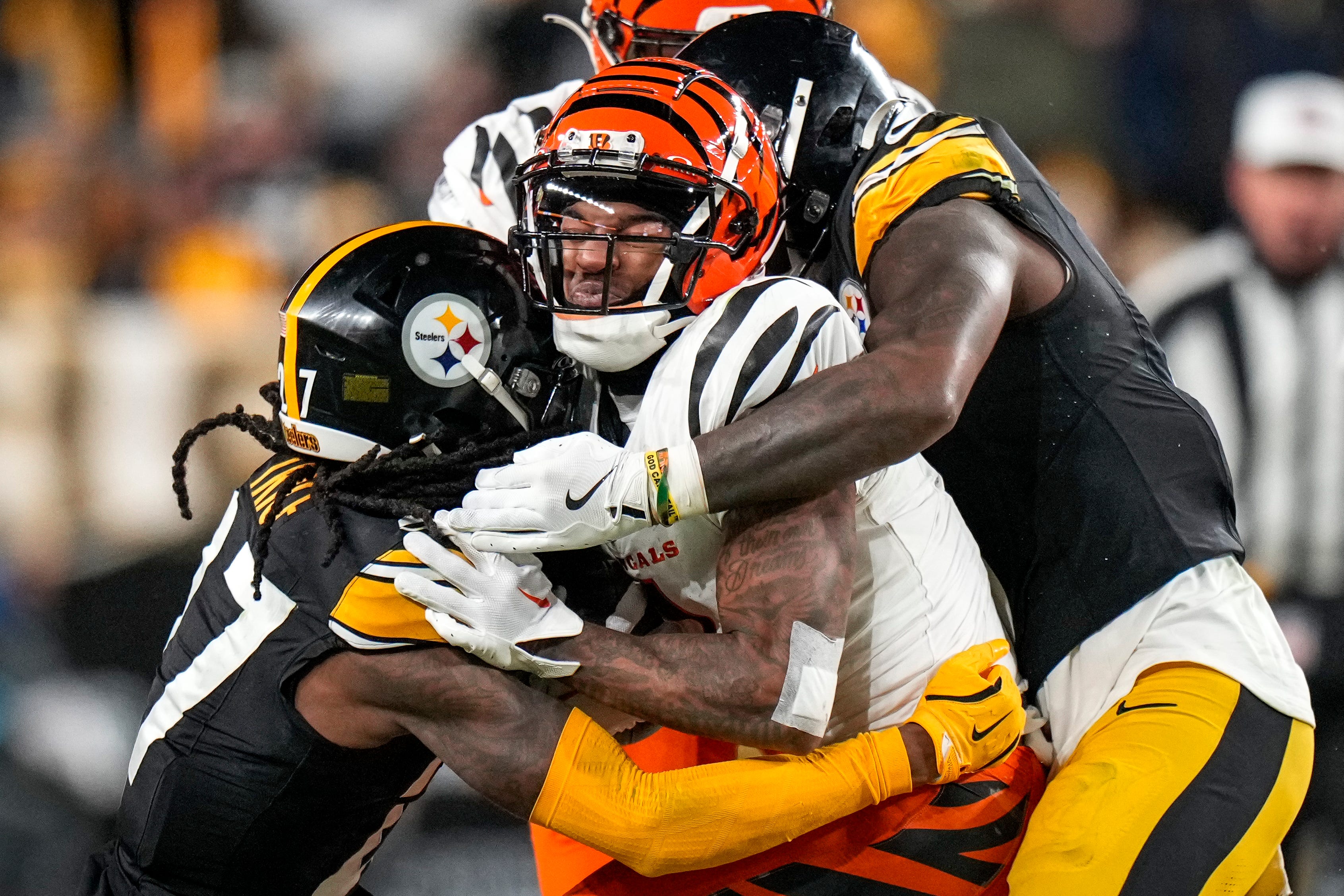 Cincinnati Bengals wide receiver Ja'Marr Chase (1) is wrapped up by Pittsburgh Steelers cornerback Cory Trice Jr. (27) on a reception in the fourth quarter of the NFL Week 18 game between the Pittsburgh Steelers and the Cincinnati Bengals at Acrisure Stadium in Pittsburgh on Saturday, Jan. 4, 2025. The Bengals won 19-17 to finish the regular season at 9-8.
