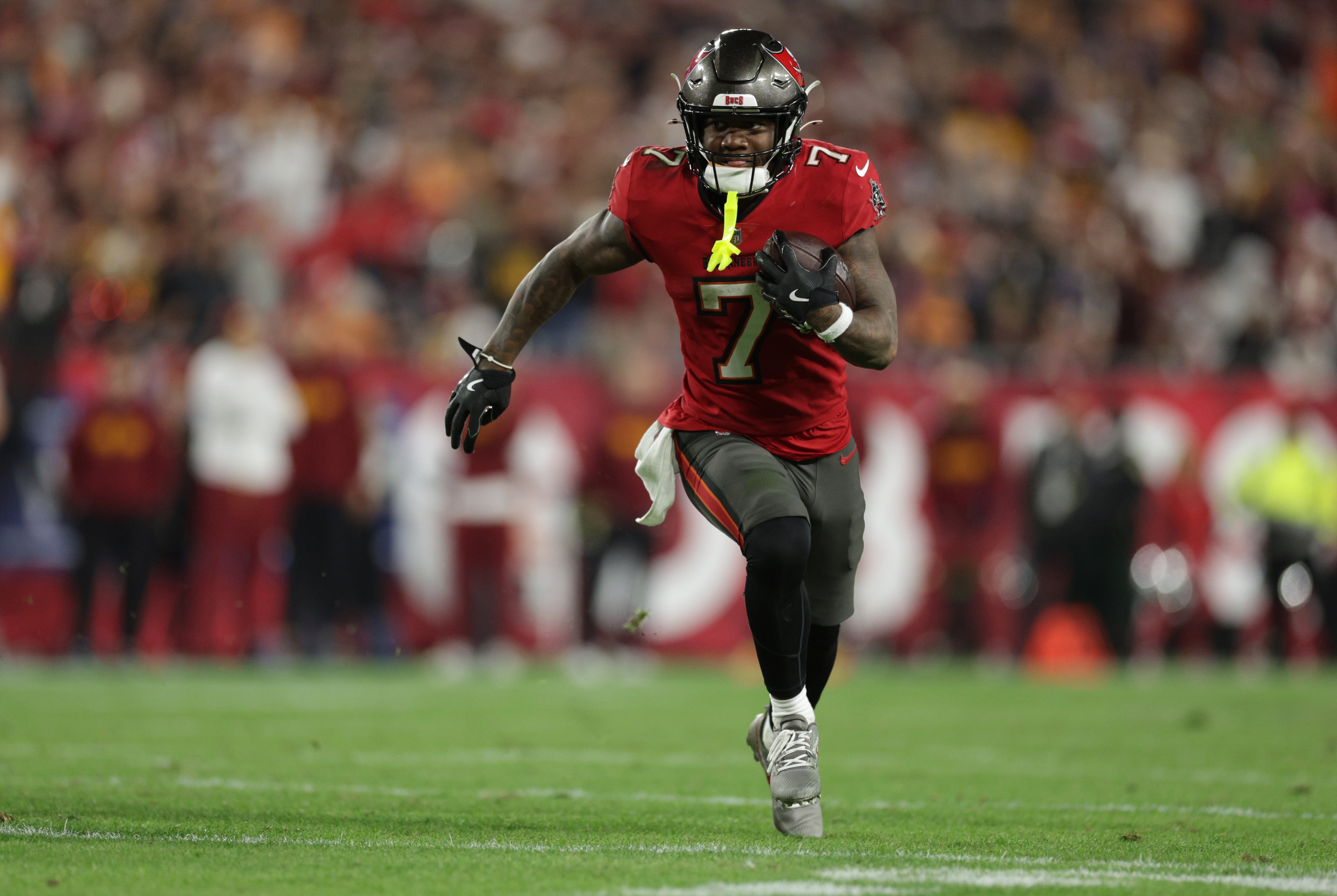 Jan 12, 2025; Tampa, Florida, USA; Tampa Bay Buccaneers running back Bucky Irving (7) runs during the fourth quarter of a NFC wild card playoff against the Washington Commanders at Raymond James Stadium.