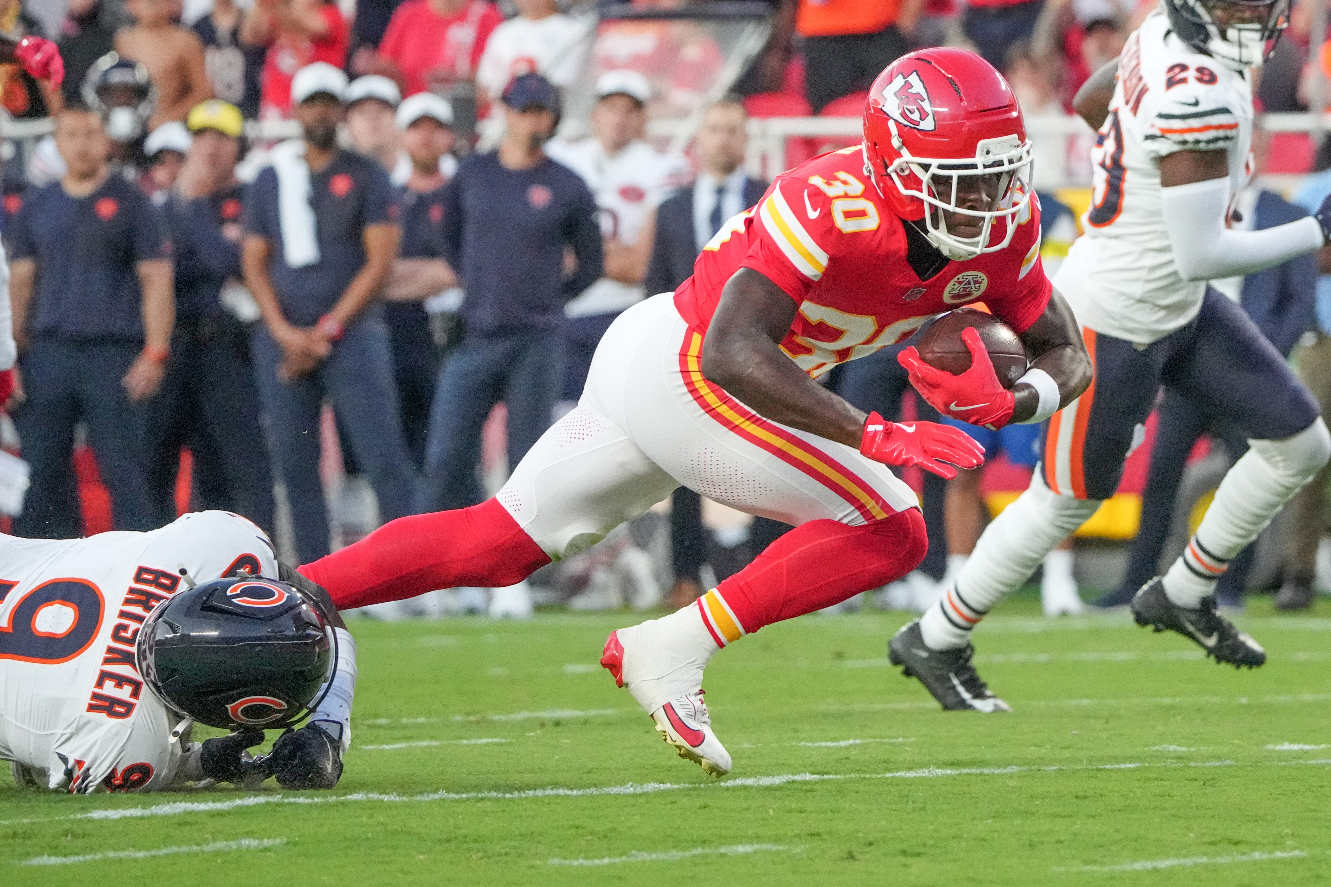 Kansas City Chiefs running back Brashard Smith (30) runs the ball as Chicago Bears safety Jaquan Brisker (9) attempts the tackle