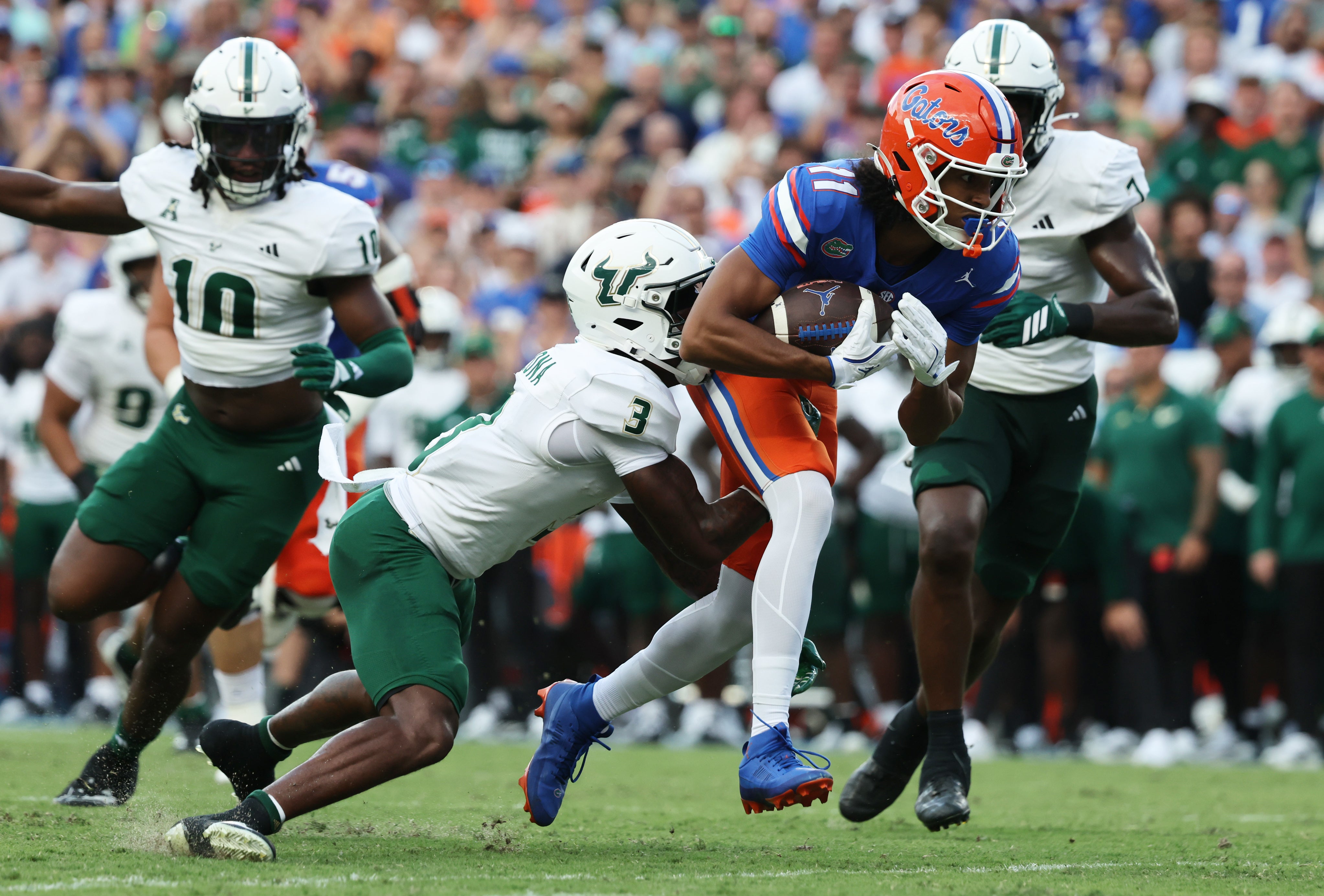 Sep 6, 2025; Gainesville, Florida, USA; Florida Gators wide receiver Aidan Mizell (11) runs with the ball as South Florida Bulls cornerback Jonas Duclona (3) tackles during the second quarter at Ben Hill Griffin Stadium.