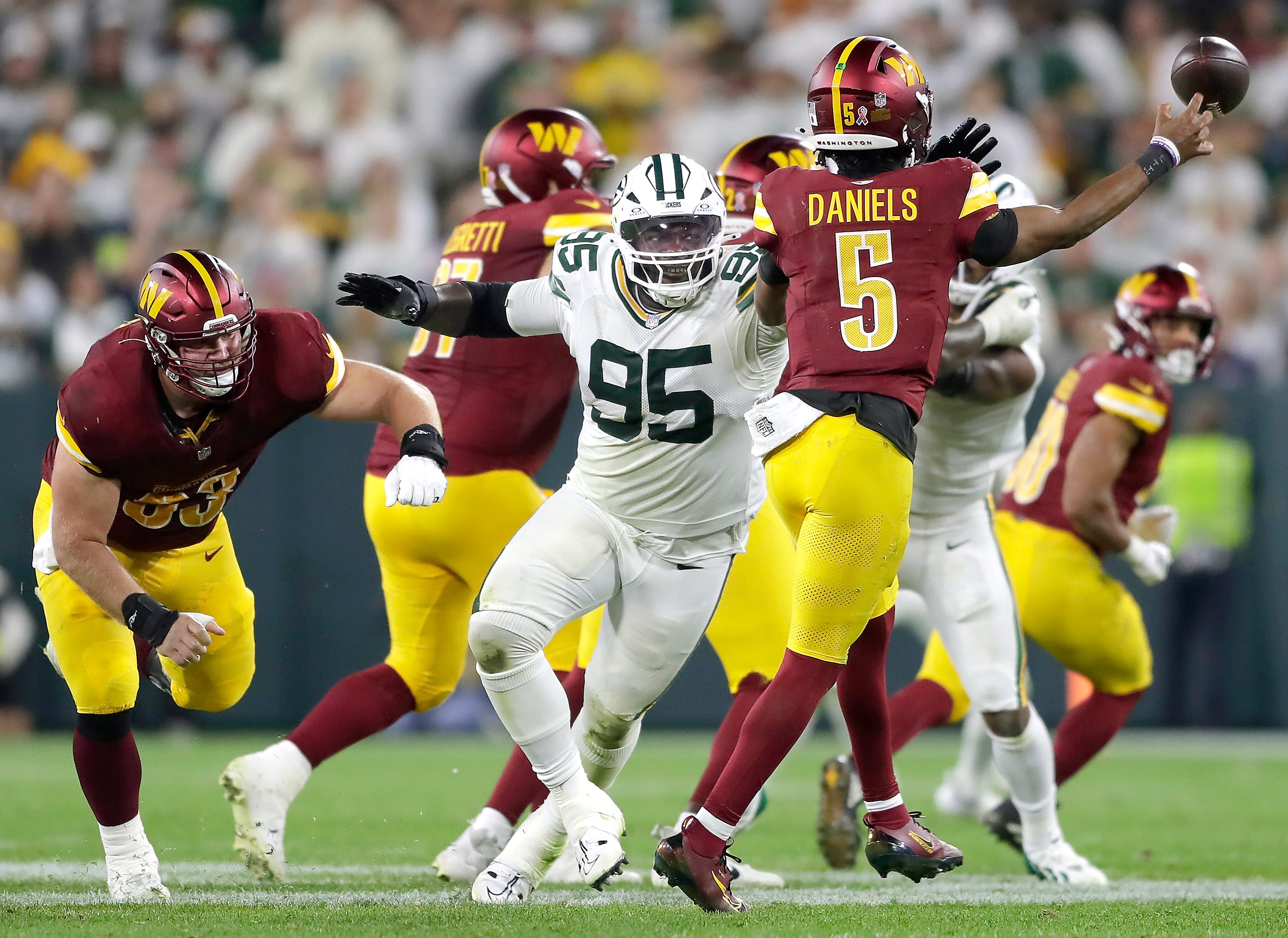 Green Bay Packers defensive tackle Devonte Wyatt (95) rpressures Washington Commanders quarterback Jayden Daniels (5) on Thursday, September 11, 2025, at Lambeau Field in Green Bay, Wis. The Packers defeated the Commanders 27-18.
