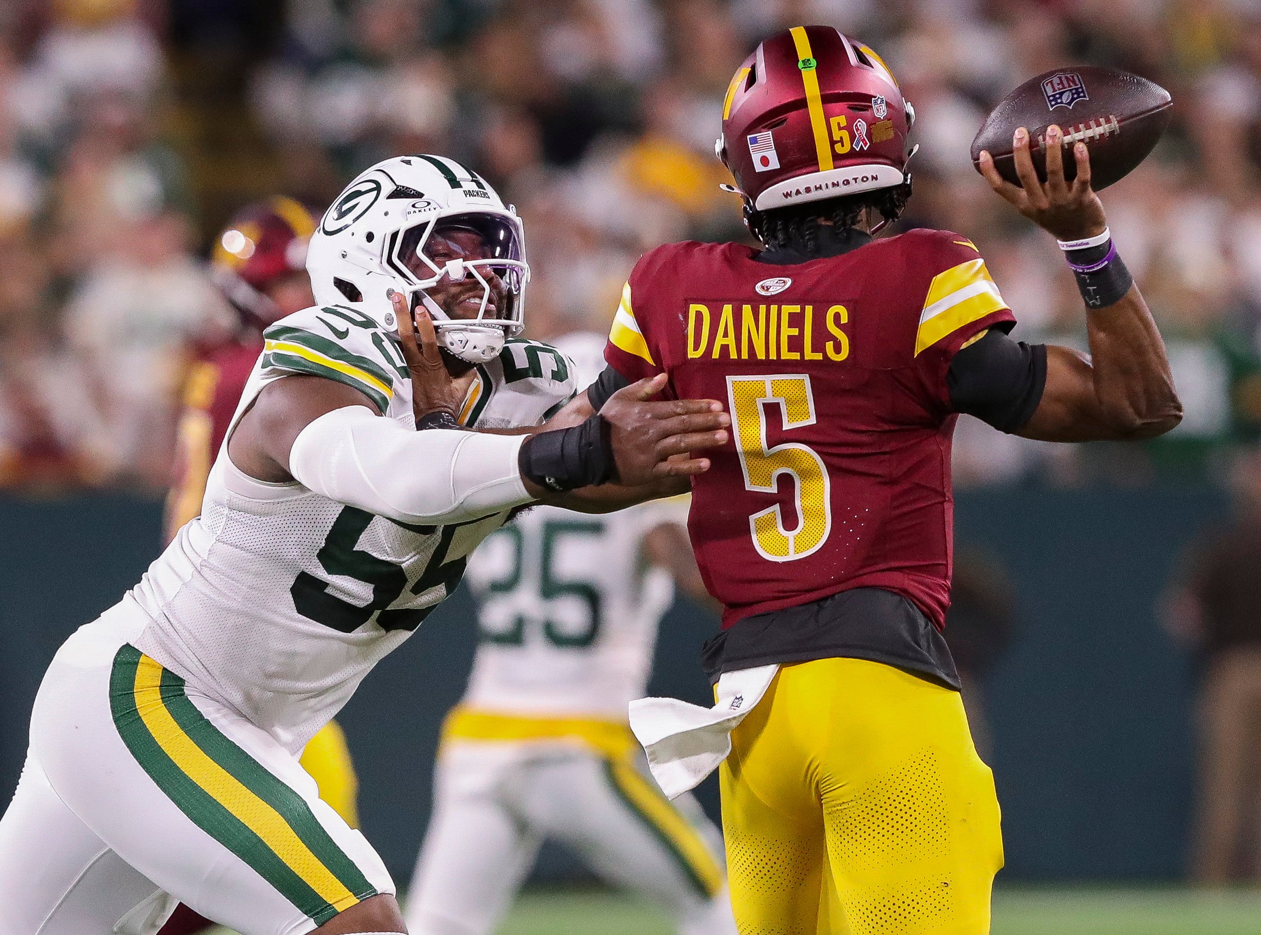 Sep 11, 2025; Green Bay, Wisconsin, USA; Green Bay Packers defensive end Kingsley Enagbare (55) pressures Washington Commanders quarterback Jayden Daniels (5) at Lambeau Field.