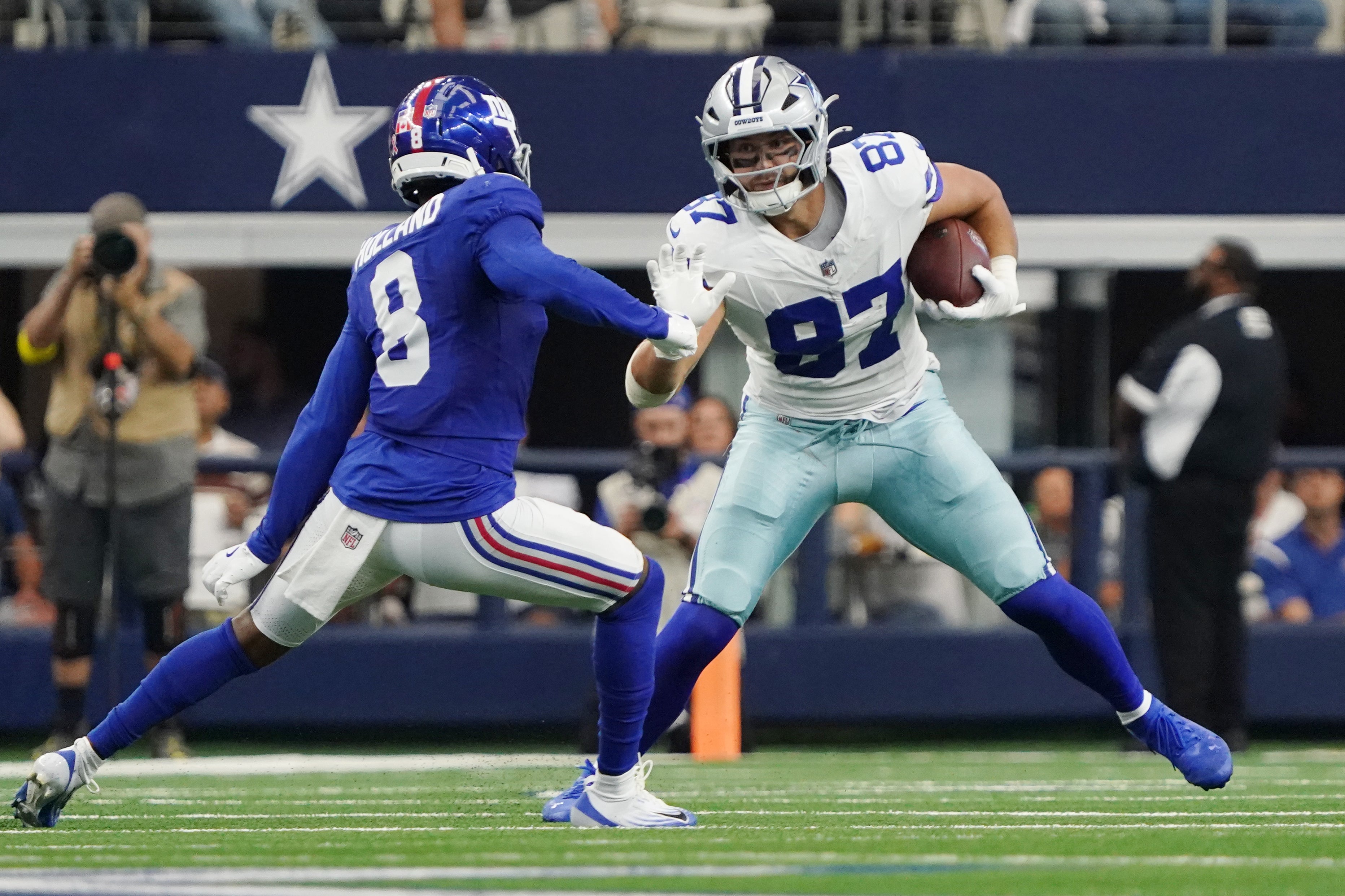 Sep 14, 2025; Arlington, Texas, USA; Dallas Cowboys tight end Jake Ferguson (87) runs with the ball against New York Giants safety Jevon Holland (8) during the second quarter at AT&T Stadium.