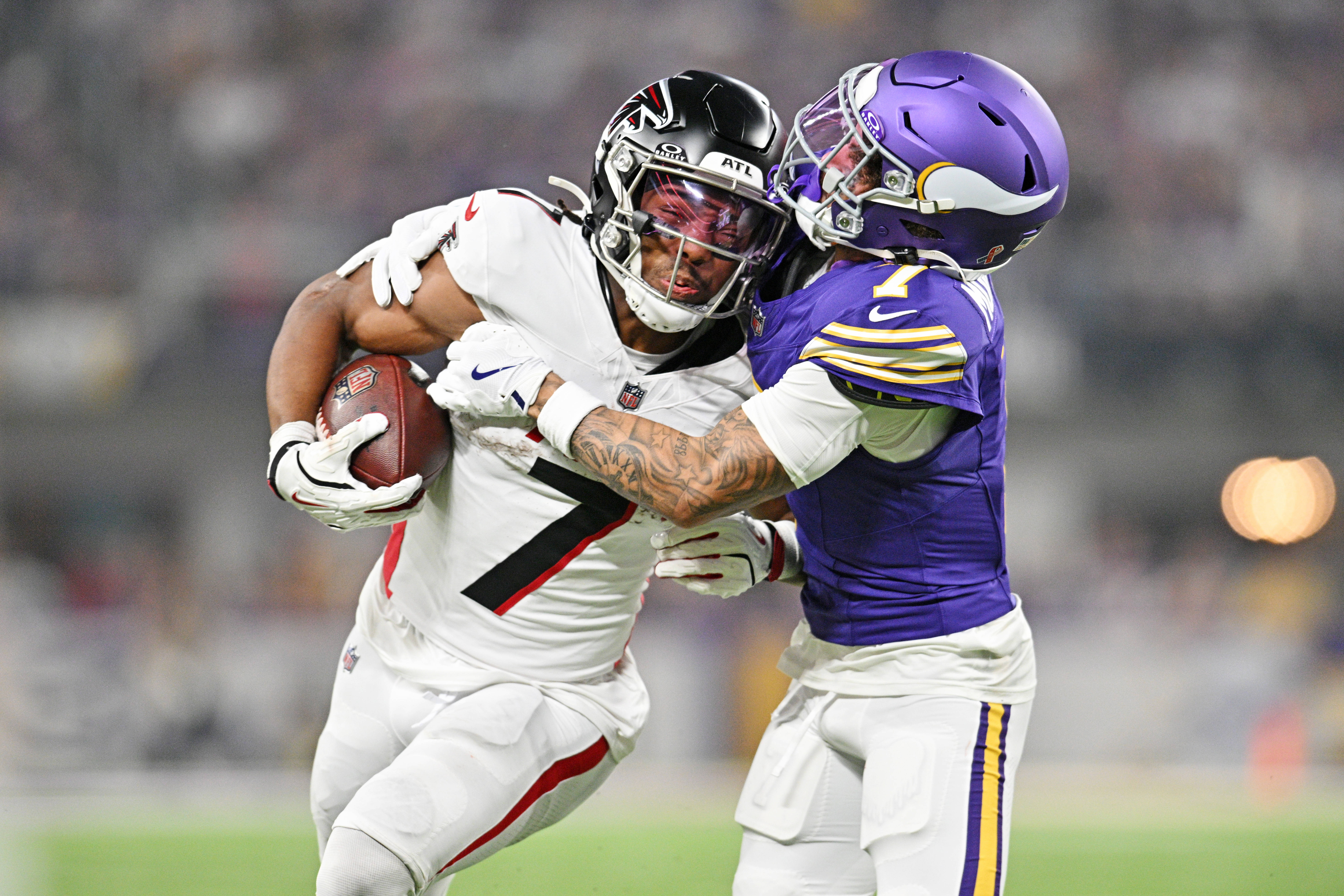 Sep 14, 2025; Minneapolis, Minnesota, USA; Atlanta Falcons running back Bijan Robinson (7) runs the ball during the first half as Minnesota Vikings cornerback Byron Murphy Jr. (7) defends at U.S. Bank Stadium.