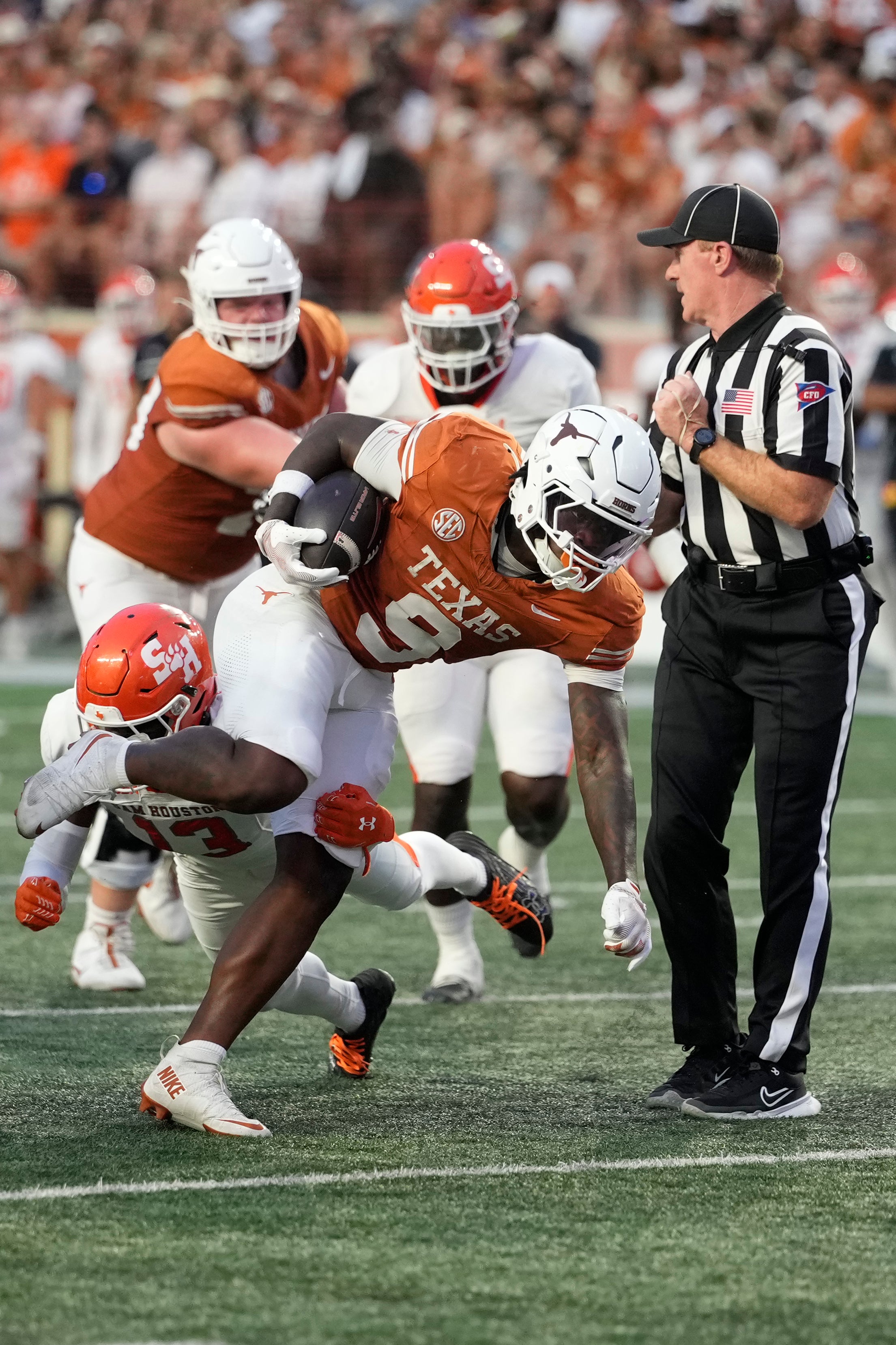 Sep 20, 2025; Austin, Texas, USA; Texas Longhorns running back Jerrick Gibson (9) evades a tackle from Sam Houston Bearkats defensive back Jadarius Evans (13) and runs towards the end zone during the first half at Darrell K Royal-Texas Memorial Stadium. Mandatory Credit: Scott Wachter-Imagn Images