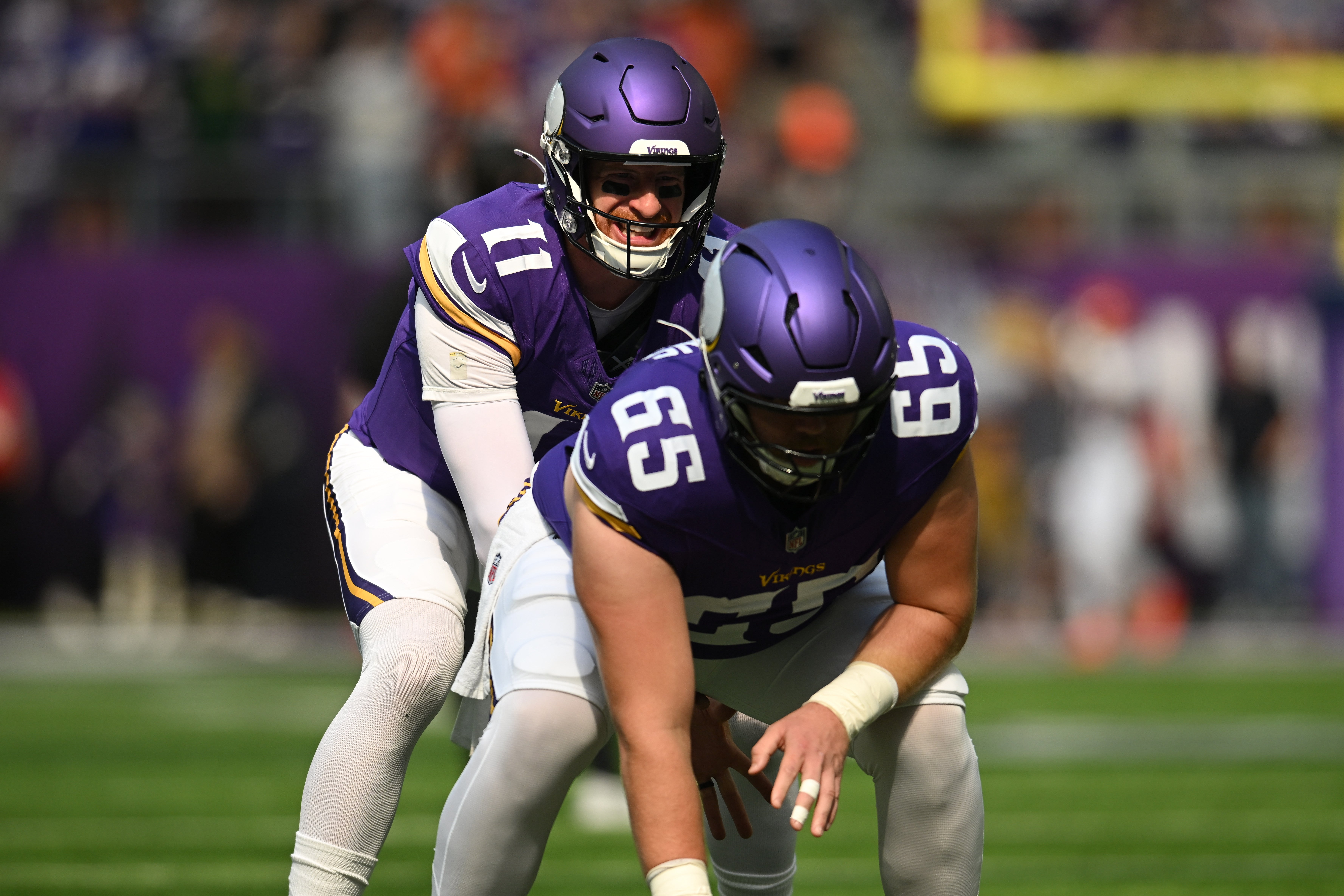 Sep 21, 2025; Minneapolis, Minnesota, USA; Minnesota Vikings quarterback Carson Wentz (11) warms up with center Michael Jurgens (65) prior to a game against the Cincinnati Bengals at U.S. Bank Stadium.