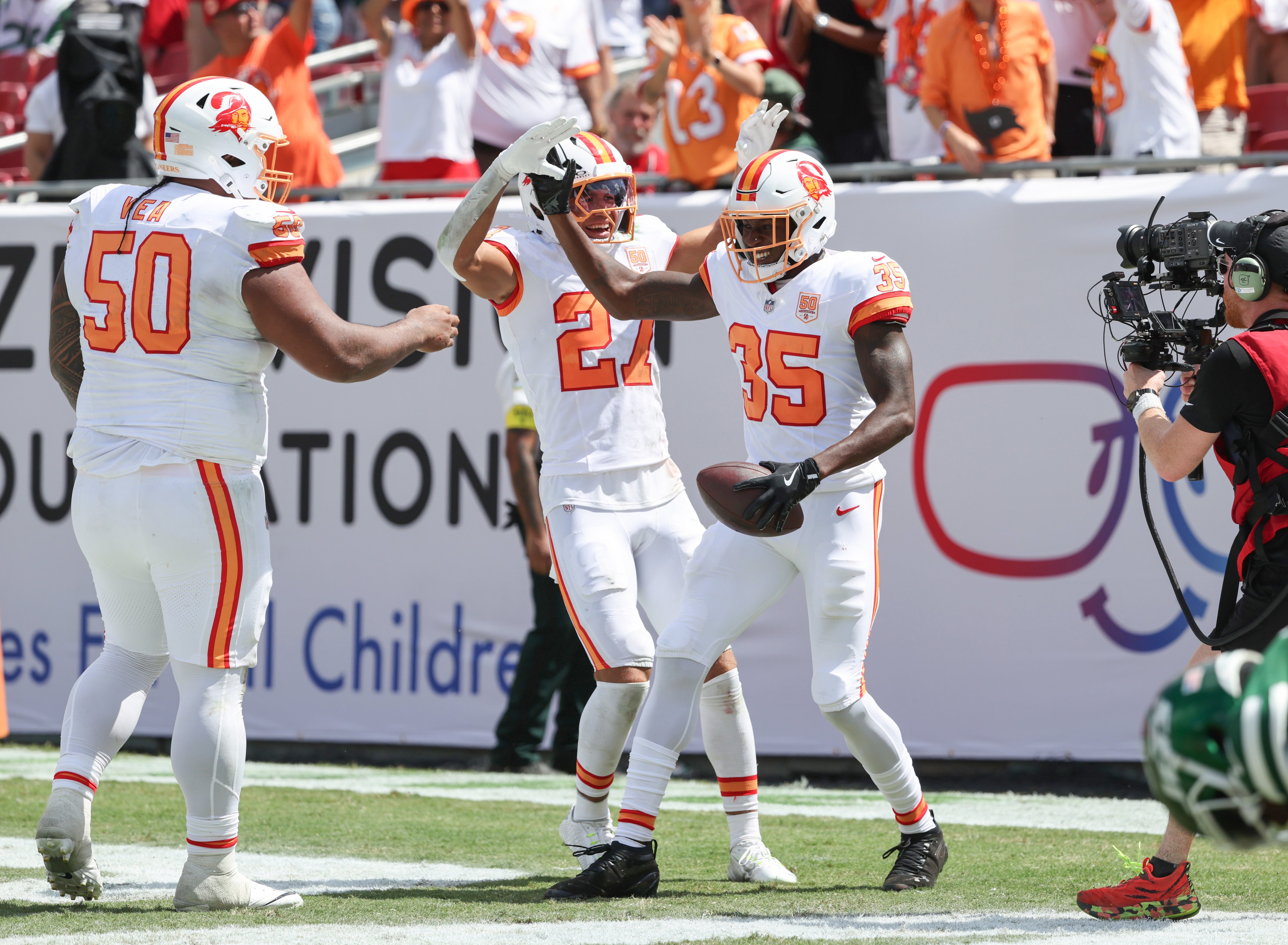 Sep 21, 2025; Tampa, Florida, USA; Tampa Bay Buccaneers cornerback Jamel Dean (35) is congratulated by cornerback Zyon McCollum (27) and defensive tackle Vita Vea (50) after he returned an intercepted back for a touchdown against the New York Jets during the second quarter at Raymond James Stadium.