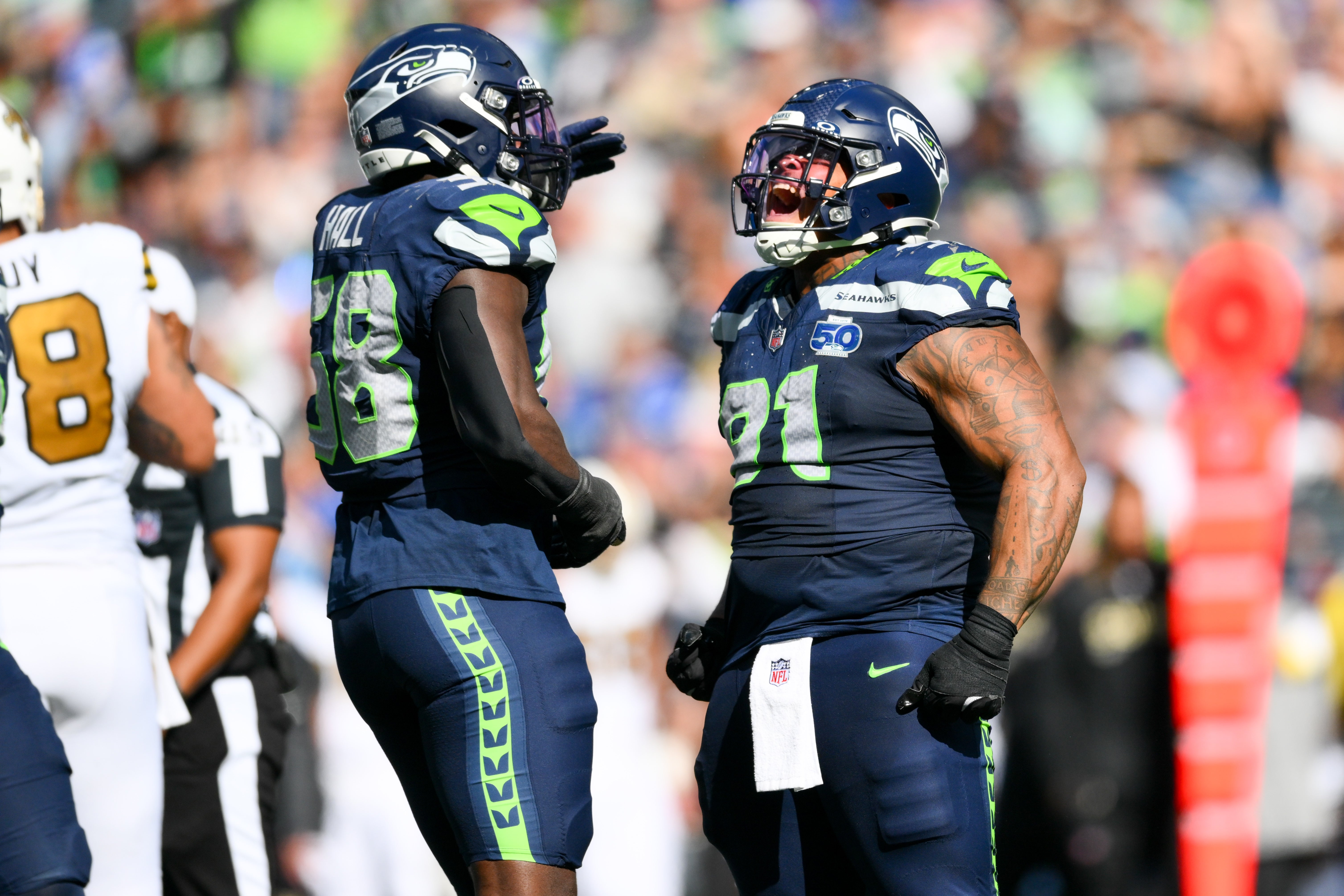 Sep 21, 2025; Seattle, Washington, USA; Seattle Seahawks defensive tackle Byron Murphy II (91) and linebacker Derick Hall (58) celebrate a sack against New Orleans Saints quarterback Spencer Rattler (2) during the third quarter at Lumen Field.