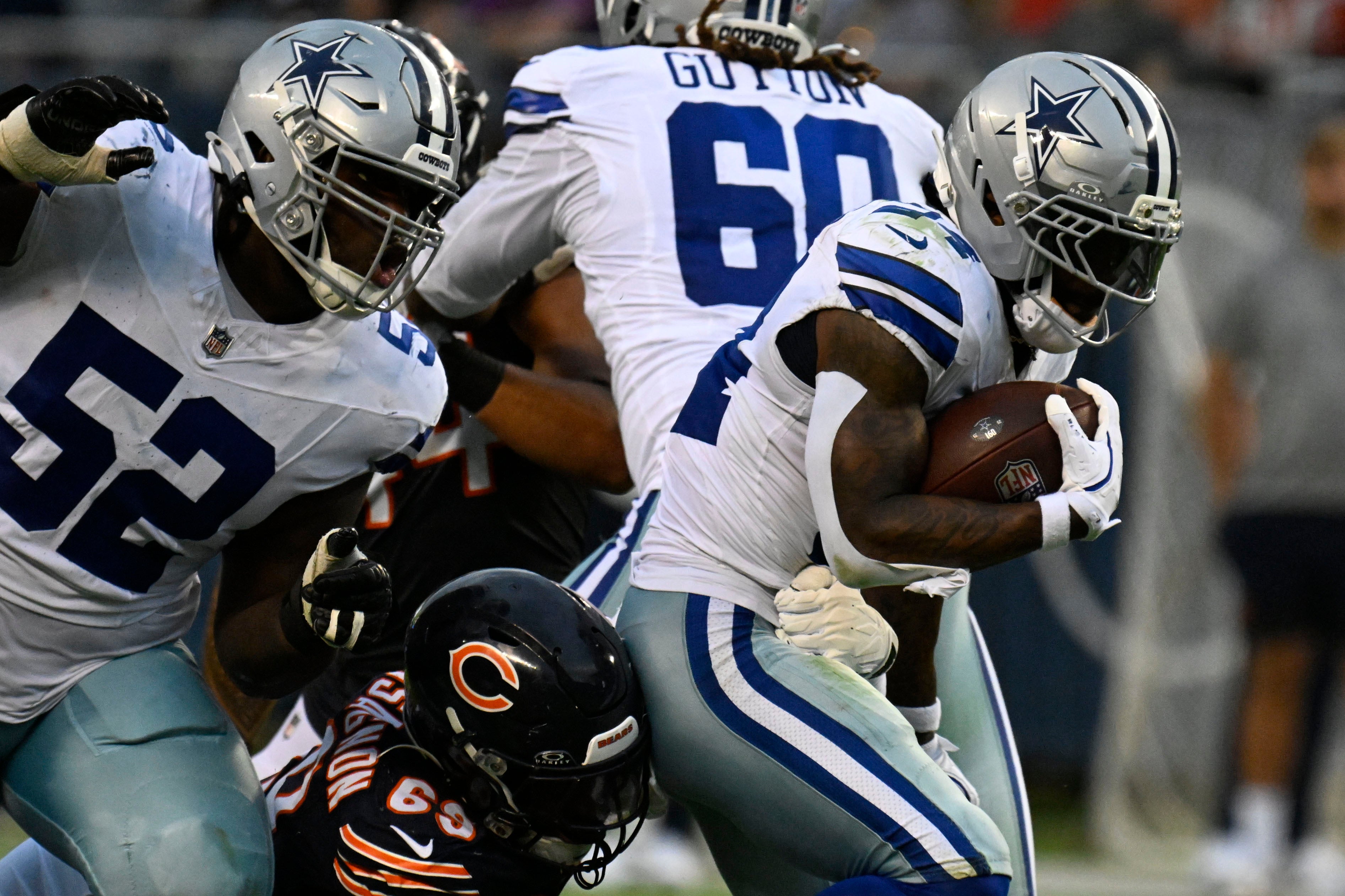 Sep 21, 2025; Chicago, Illinois, USA; Dallas Cowboys running back Miles Sanders (24) rushes the ball against the Chicago Bears during the second half at Soldier Field.
