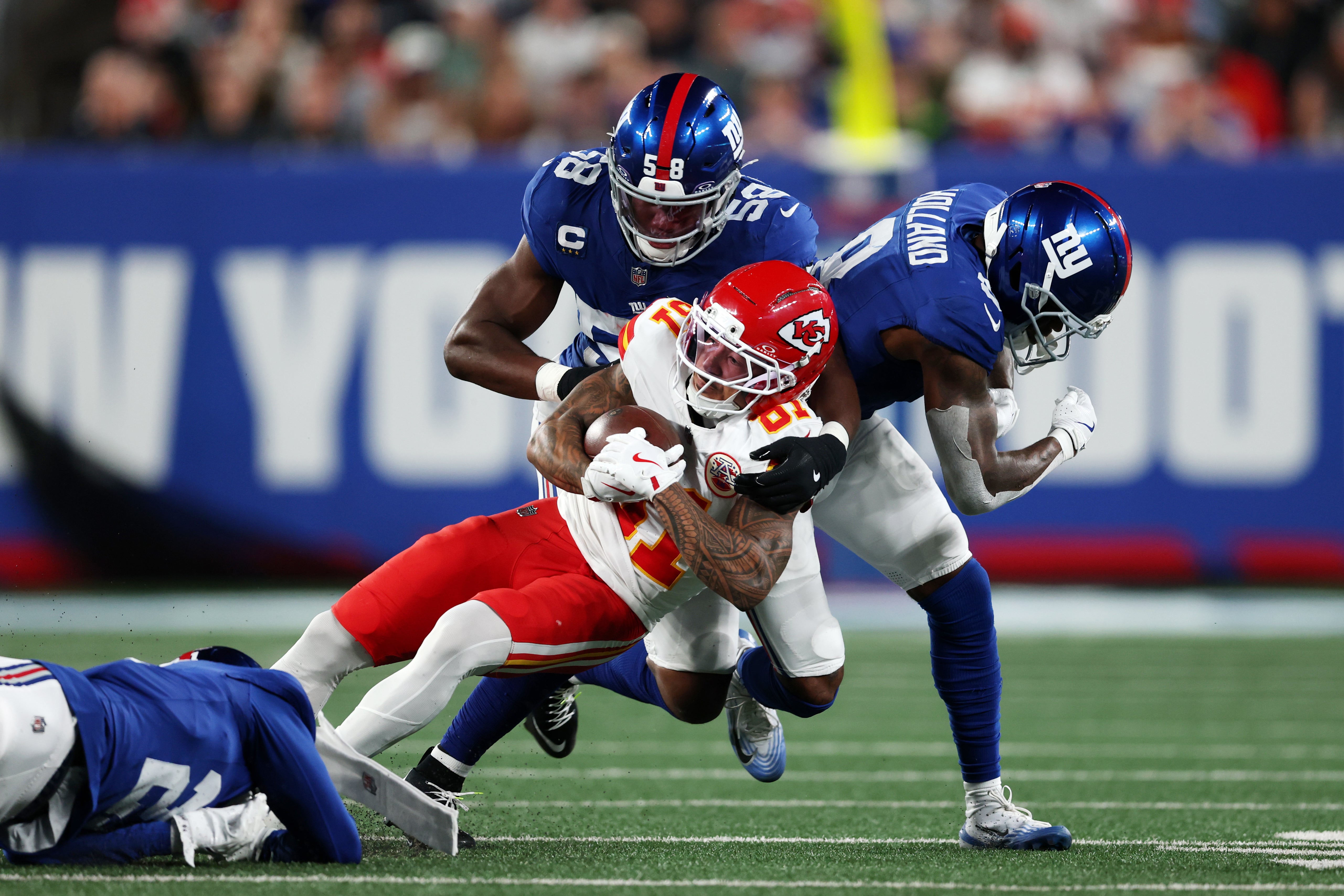 Sep 21, 2025; East Rutherford, New Jersey, USA; New York Giants inside linebacker Bobby Okereke (58) and safety Jevon Holland (8) and cornerback Paulson Adebo (21) tackle Kansas City Chiefs wide receiver Nikko Remigio (81) in the second quarter at MetLife Stadium.