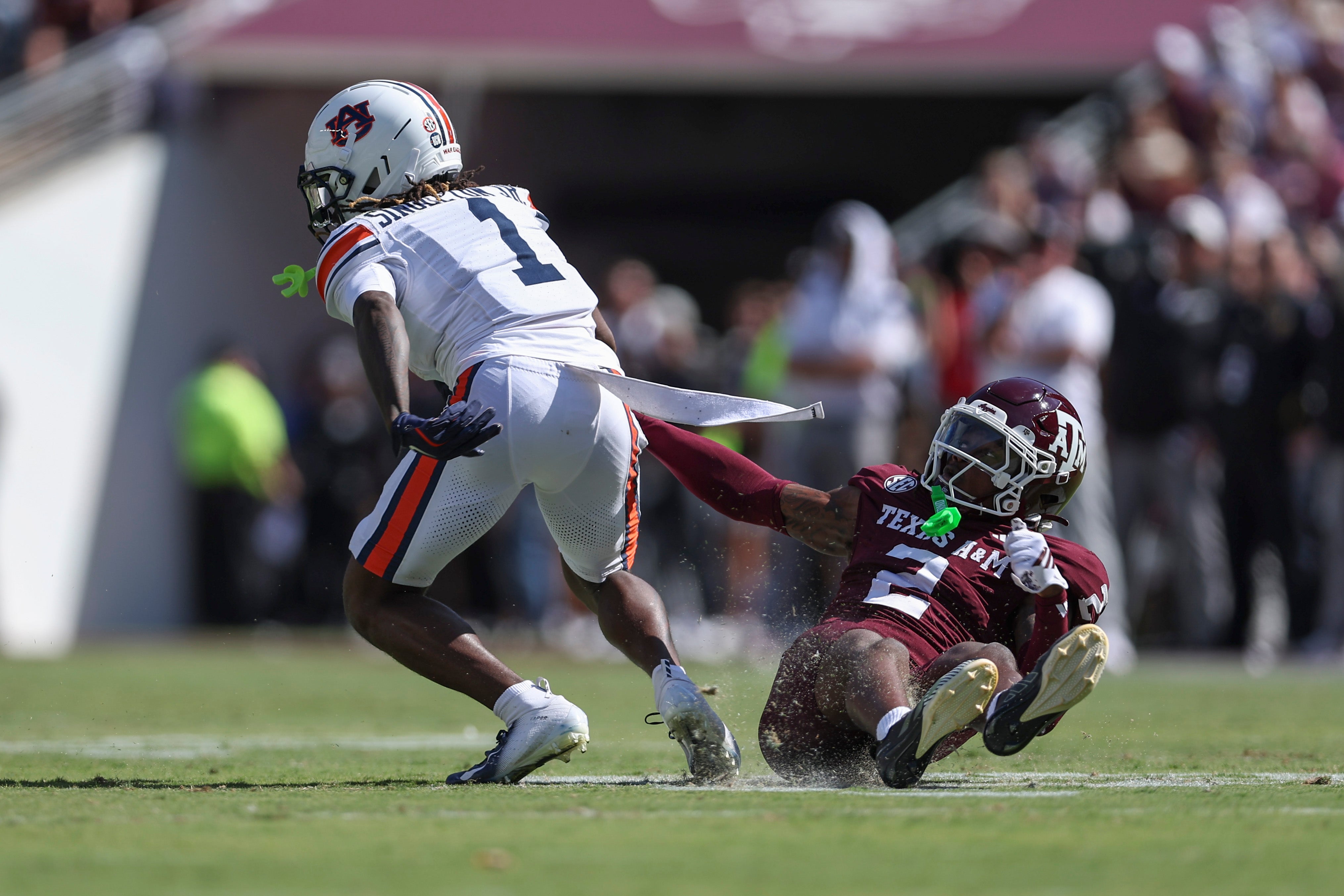 Sep 27, 2025; College Station, Texas, USA; Auburn Tigers wide receiver Eric Singleton Jr. (1) slips past Texas A&M Aggies cornerback Dezz Ricks (2) after a reception during the second quarter at Kyle Field. Mandatory Credit: Troy Taormina-Imagn Images