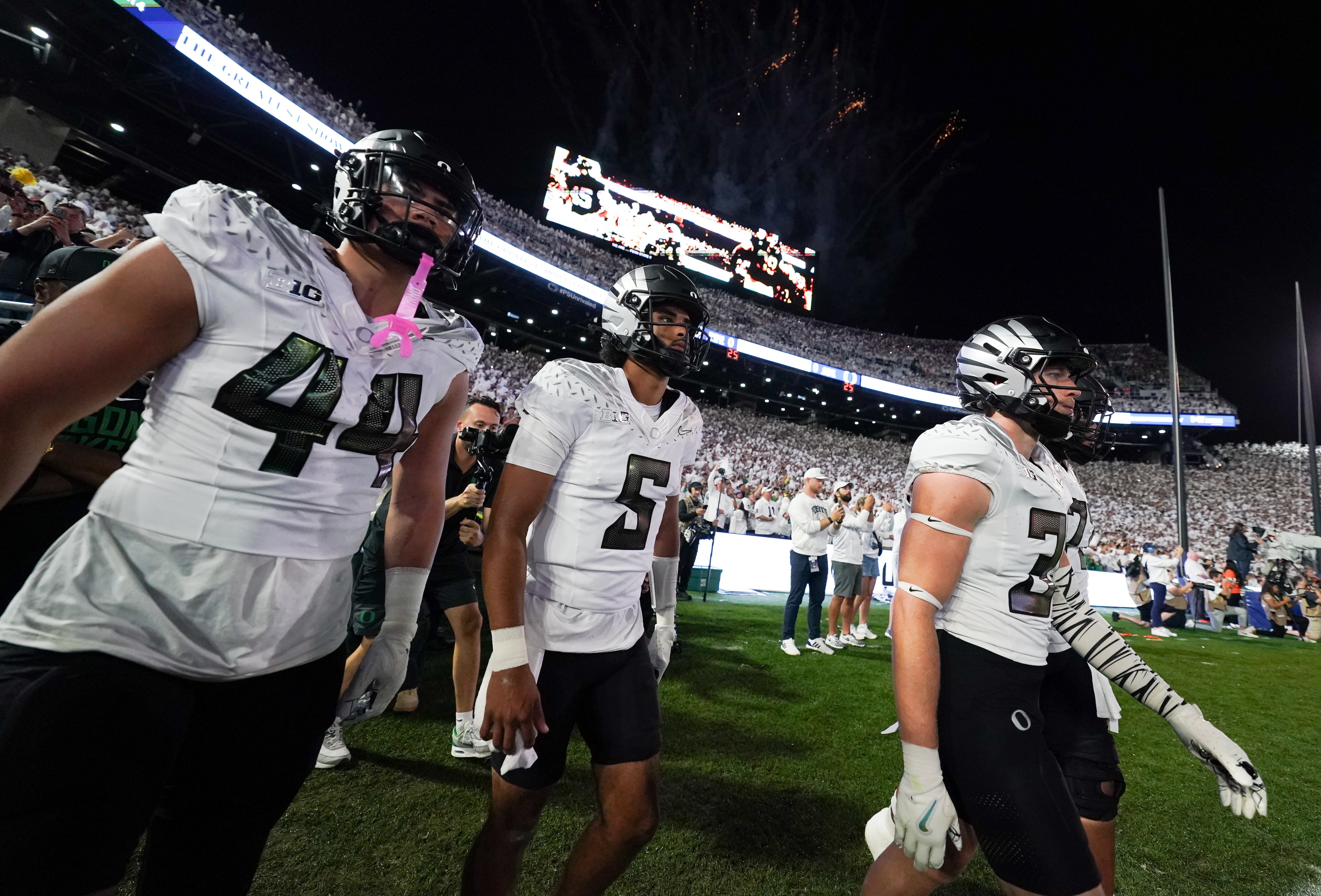 Sep 27, 2025; University Park, Pennsylvania, USA; Oregon Ducks linebacker Teitum Tuioti (44), quarterback Dante Moore (5) and wide receiver Gary Bryant Jr. (2) take the field prior to a game against the Penn State Nittany Lions at Beaver Stadium. Mandatory Credit: James Lang-Imagn Images