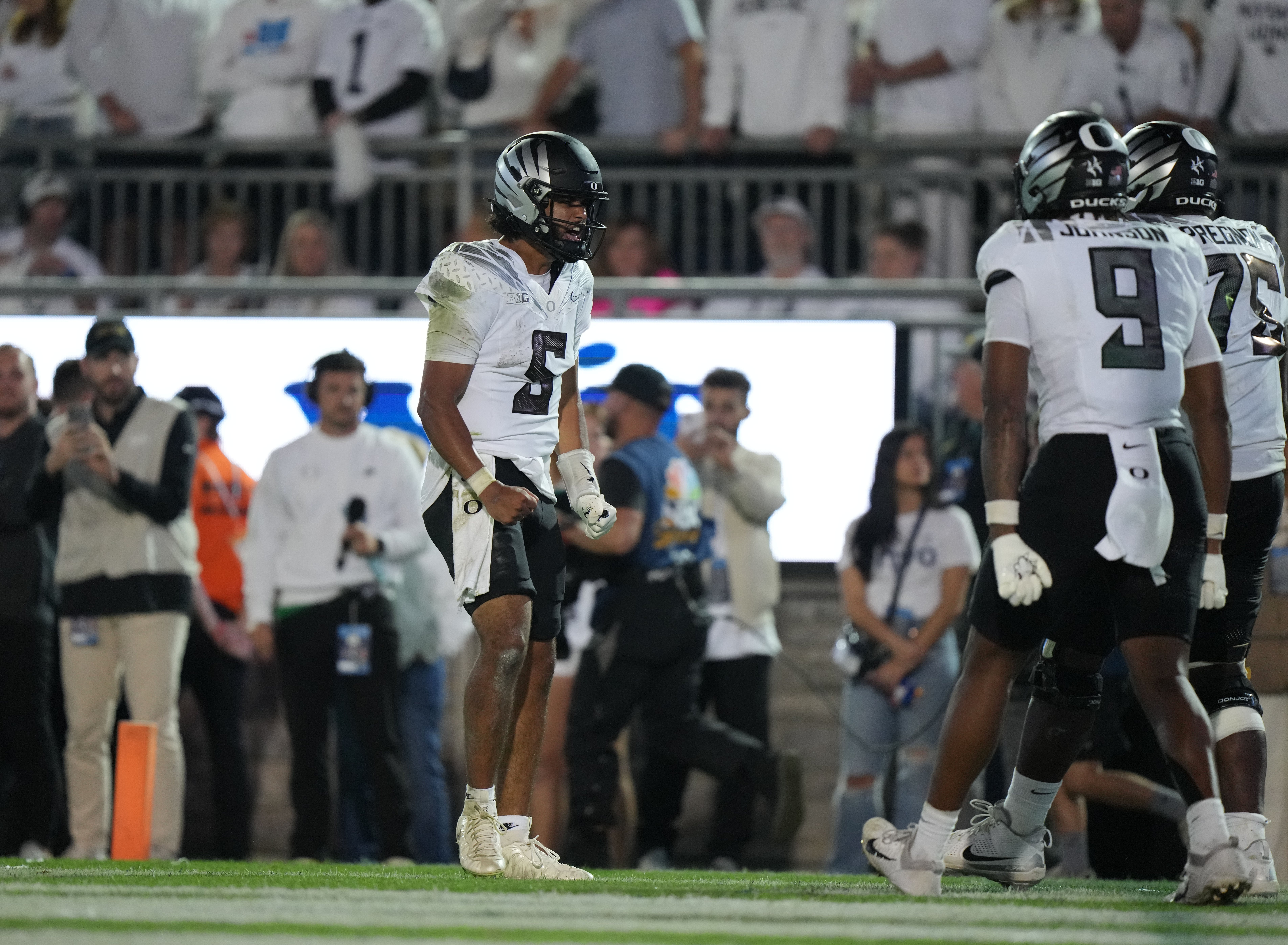 Sep 27, 2025; University Park, Pennsylvania, USA; Oregon Ducks quarterback Dante Moore (5) reacts after a touchdown with tight end Jamari Johnson (9) and offensive lineman Emmanuel Pregnon (75) at Beaver Stadium.