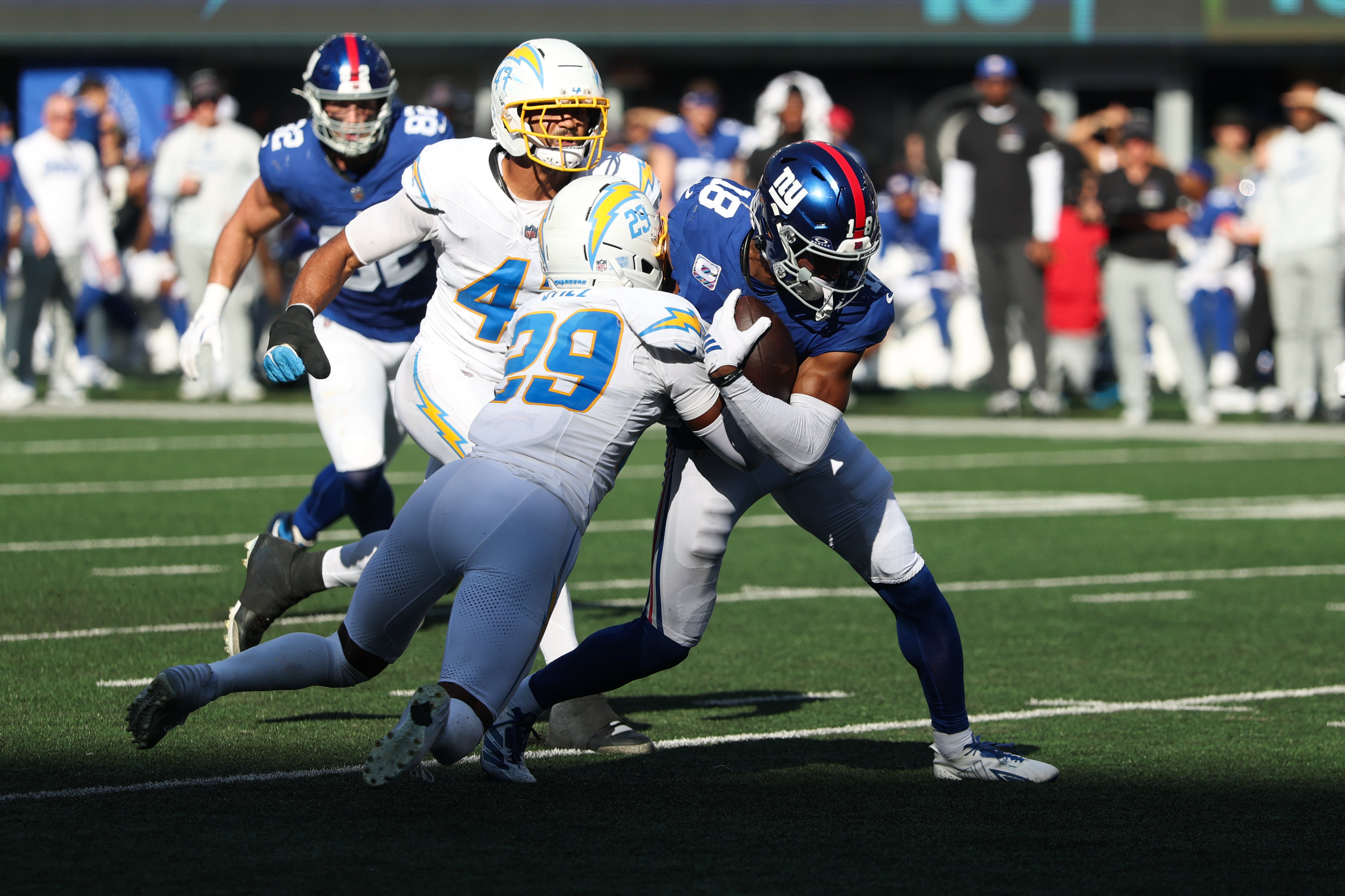 Sep 28, 2025; East Rutherford, New Jersey, USA; New York Giants wide receiver Darius Slayton (18) runs after making a catch as Los Angeles Chargers cornerback Tarheeb Still (29) defends during the fourth quarter at MetLife Stadium.
