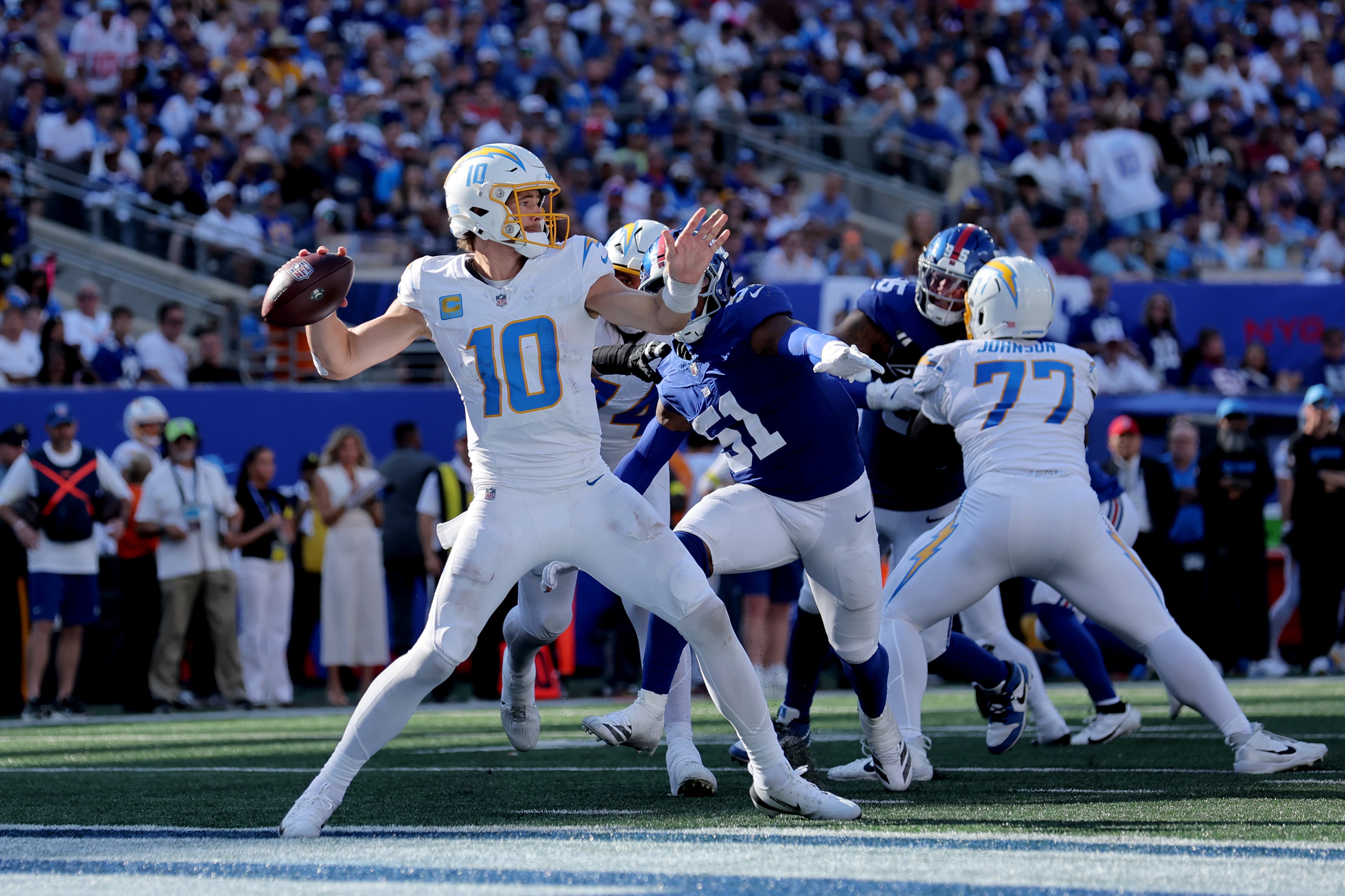 Sep 28, 2025; East Rutherford, New Jersey, USA; Los Angeles Chargers quarterback Justin Herbert (10) passes the ball against New York Giants linebacker Abdul Carter (51) during the fourth quarter at MetLife Stadium. Mandatory Credit: Brad Penner-Imagn Images
