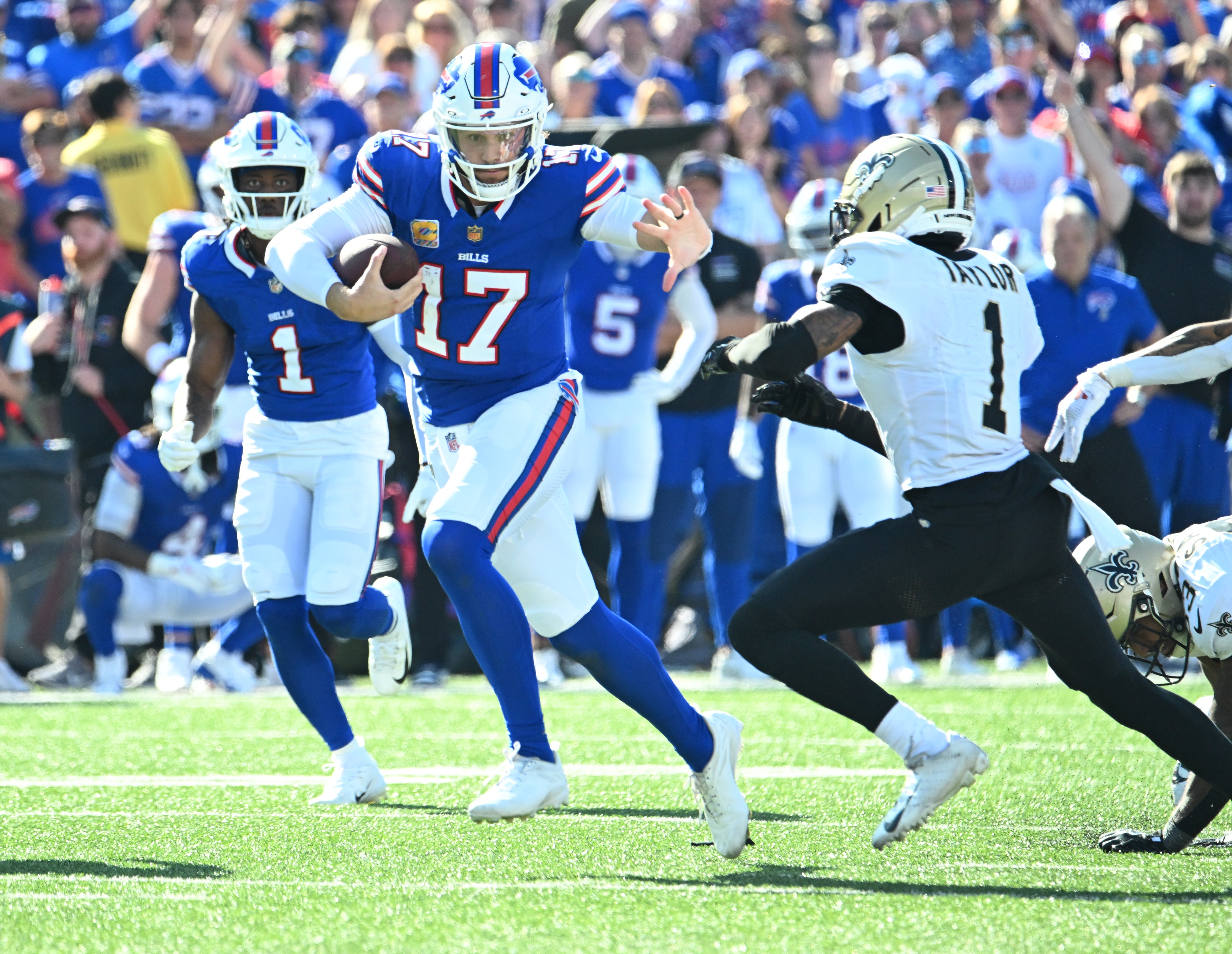 Sep 28, 2025; Orchard Park, New York, USA; Buffalo Bills quarterback Josh Allen (17) runs for a gain past New Orleans Saints cornerback Alontae Taylor (1) during the fourth quarter at Highmark Stadium.