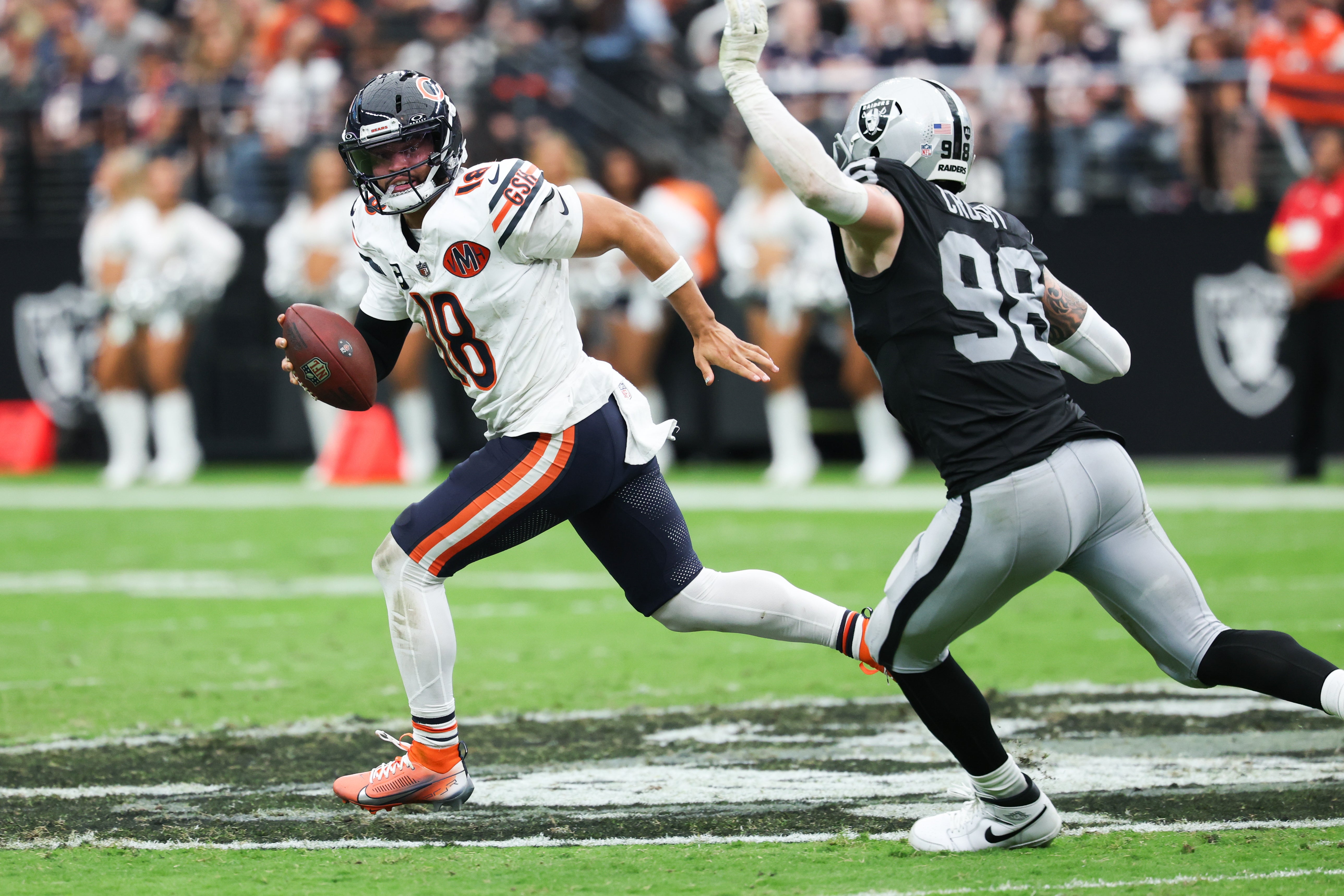 Sep 28, 2025; Paradise, Nevada, USA; Chicago Bears quarterback Caleb Williams (18) looks for an open receiver while being pressured by Las Vegas Raiders defensive end Maxx Crosby (98) in the second quarter at Allegiant Stadium.