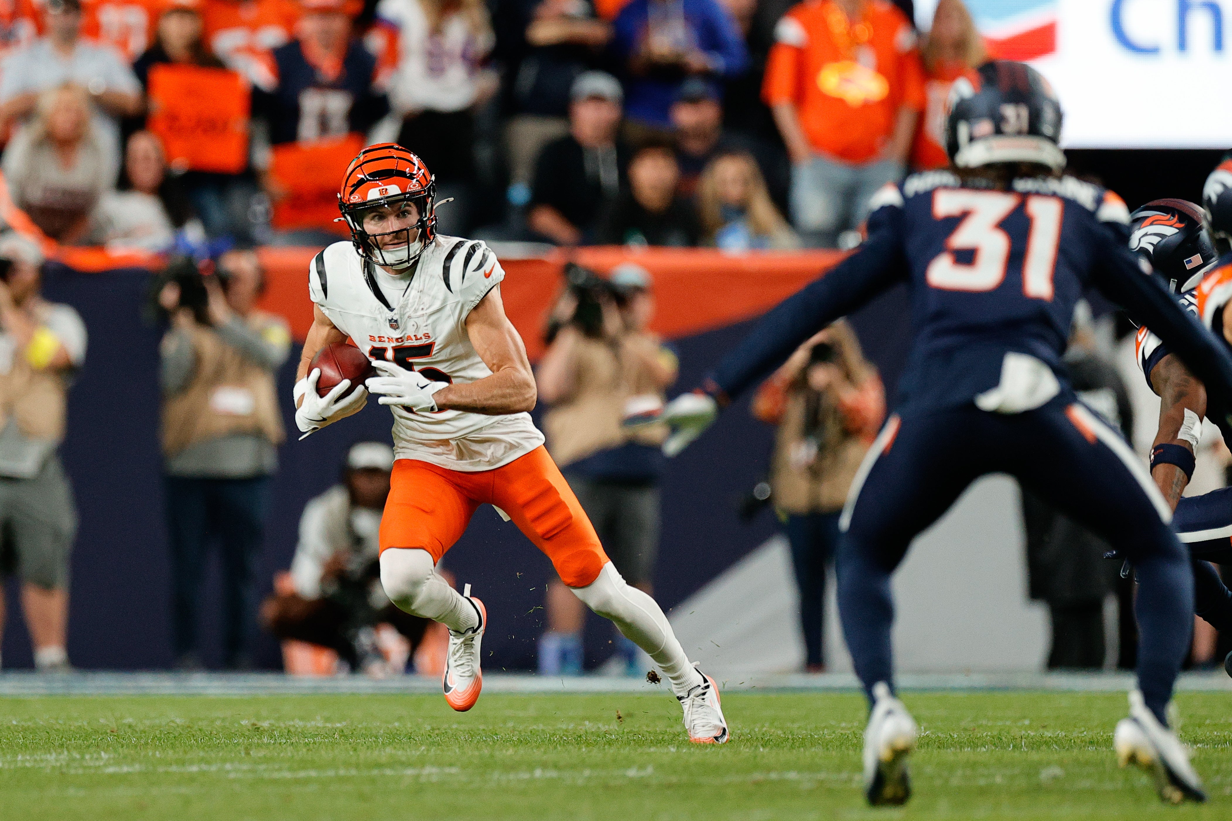 Sep 29, 2025; Denver, Colorado, USA; Cincinnati Bengals wide receiver Charlie Jones (15) runs after making a catch as Denver Broncos cornerback Kris Abrams-Draine (31) defends during the second quarter at Empower Field at Mile High.