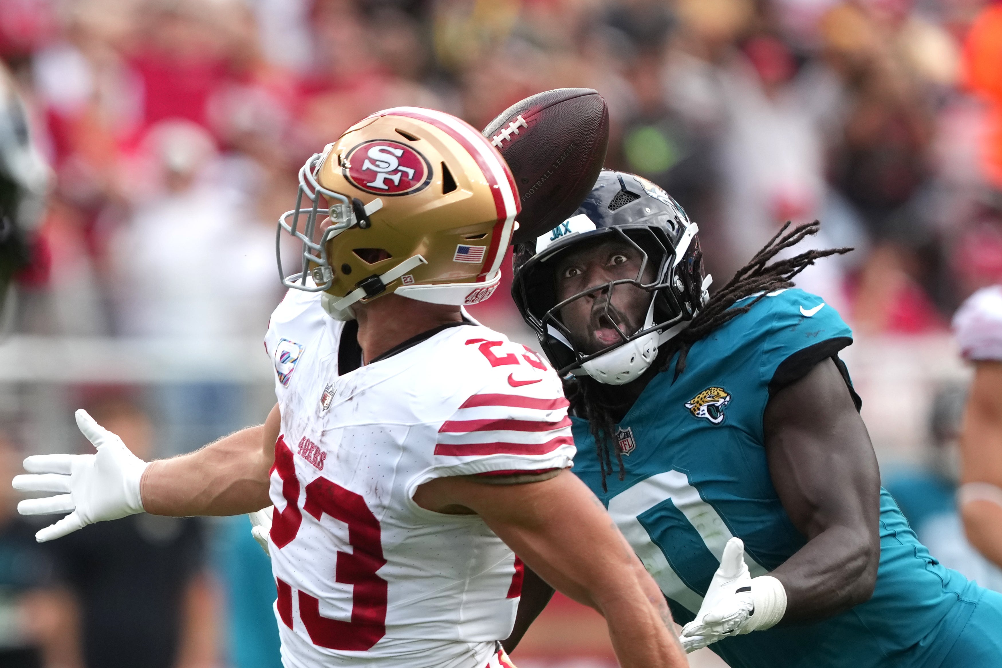Sep 28, 2025; Santa Clara, California, USA; Jacksonville Jaguars linebacker Devin Lloyd (0) catches a bobbled ball by San Francisco 49ers running back Christian McCaffrey (23) for an interception during the second quarter at Levi's Stadium.