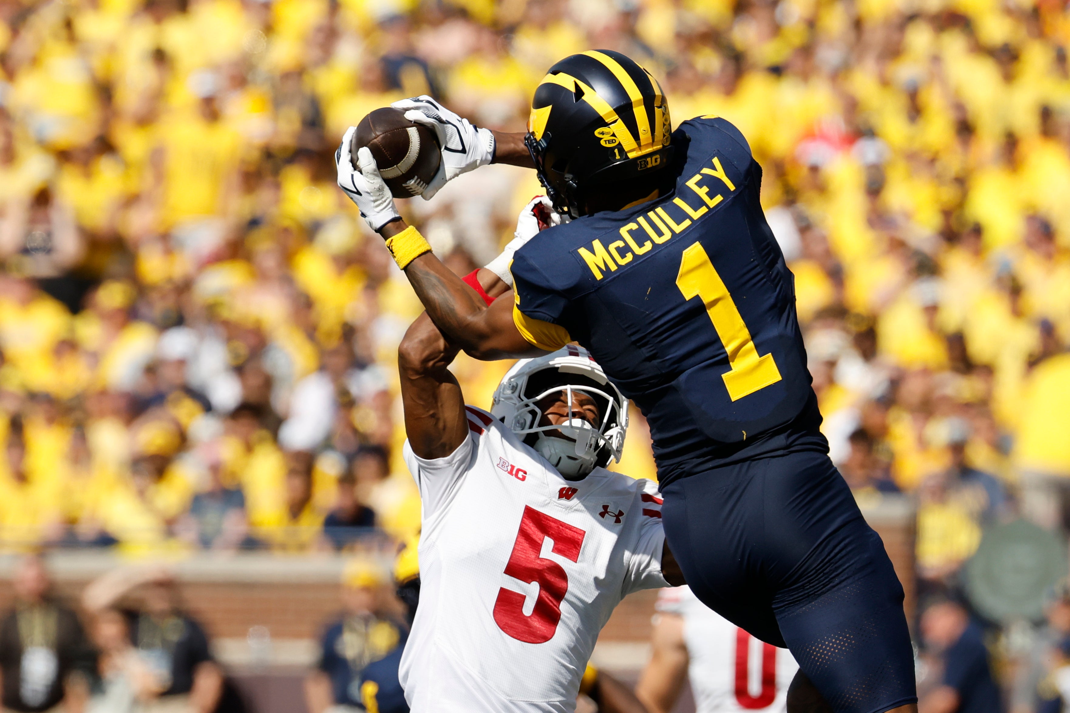 Oct 4, 2025; Ann Arbor, Michigan, USA; Michigan Wolverines wide receiver Donaven McCulley (1) makes a reception defended by Wisconsin Badgers cornerback D'Yoni Hill (5) in the second half at Michigan Stadium.
