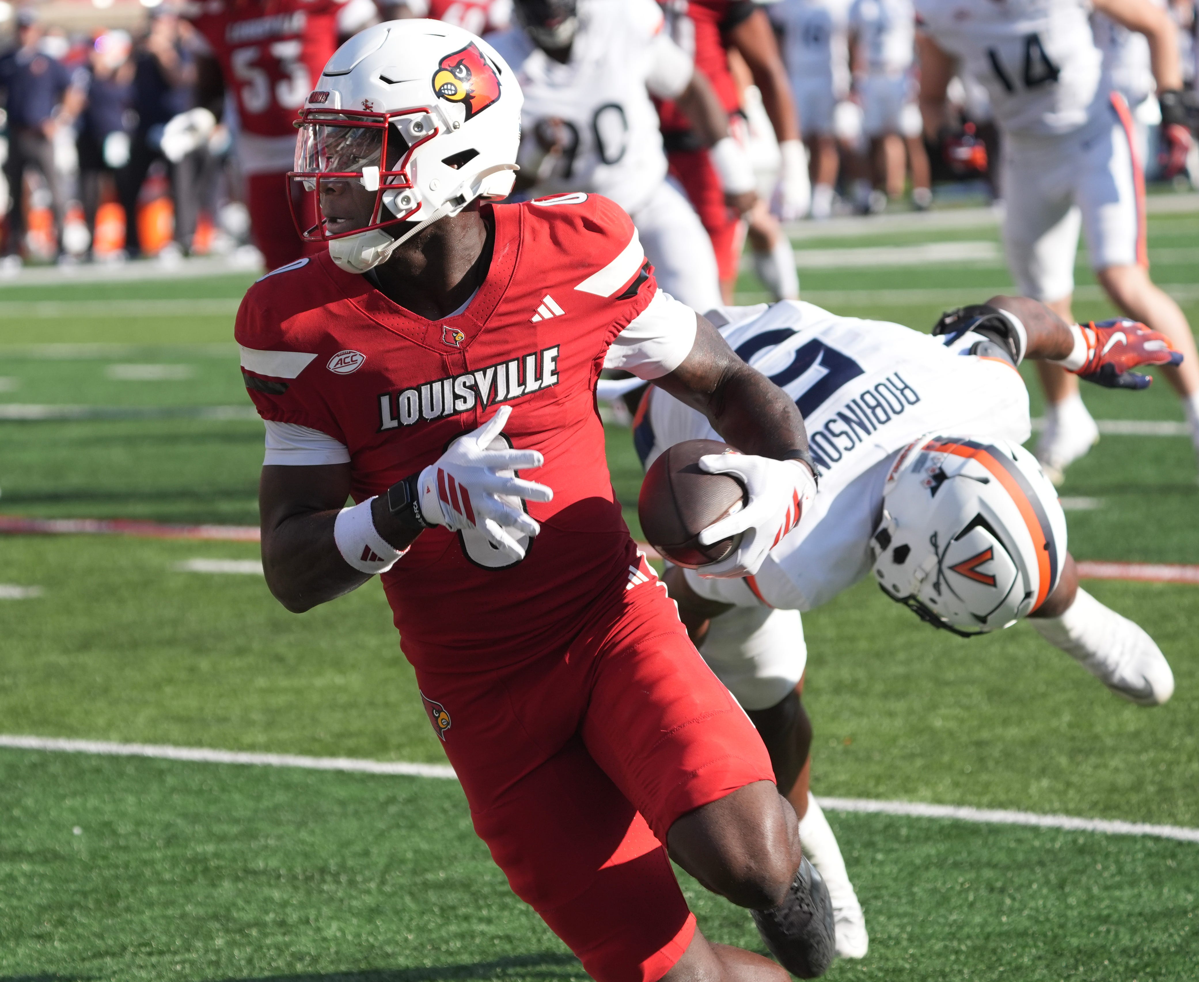 Louisville’s Chris Bell makes Virginia’s Kam Robinson miss and scores a touchdown at L&N Stadium Saturday.