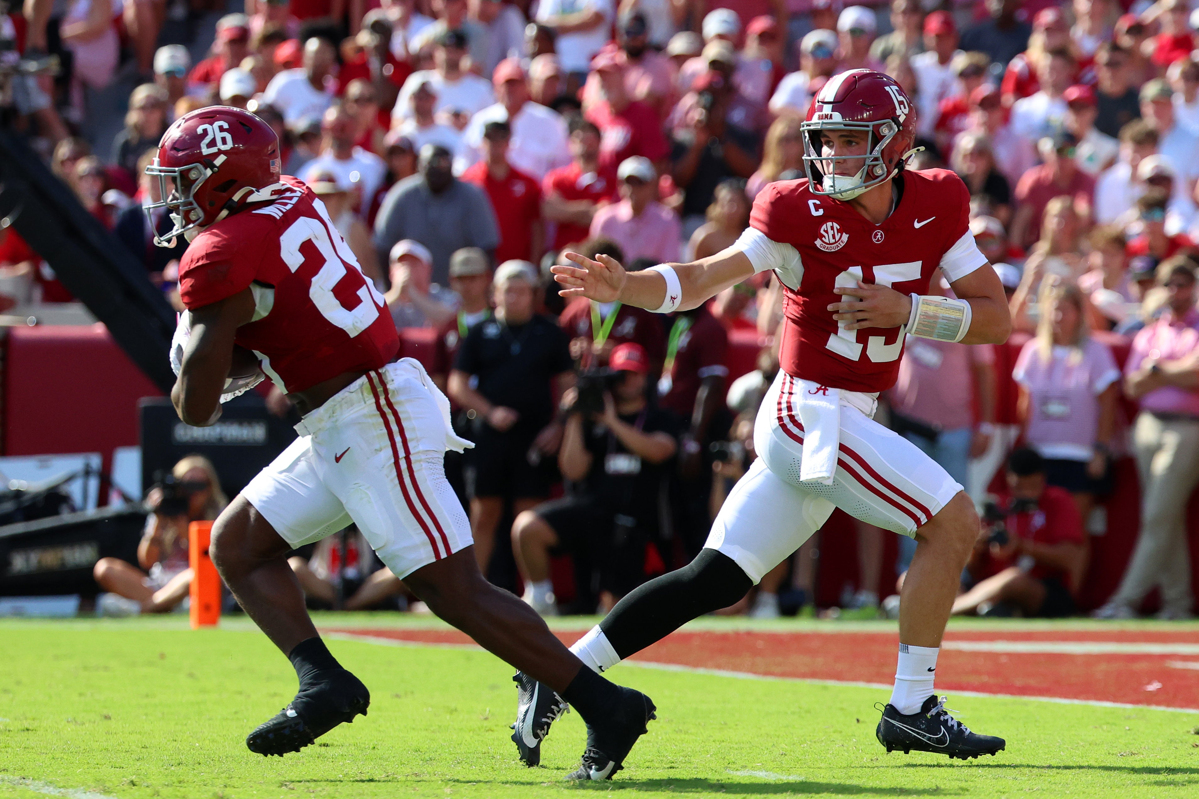 Oct 4, 2025; Tuscaloosa, Alabama, USA; Alabama Crimson Tide quarterback Ty Simpson (15) hands the ball off to running back Jam Miller (26) during the first quarter against the Vanderbilt Commodores at Saban Field at Bryant-Denny Stadium.
