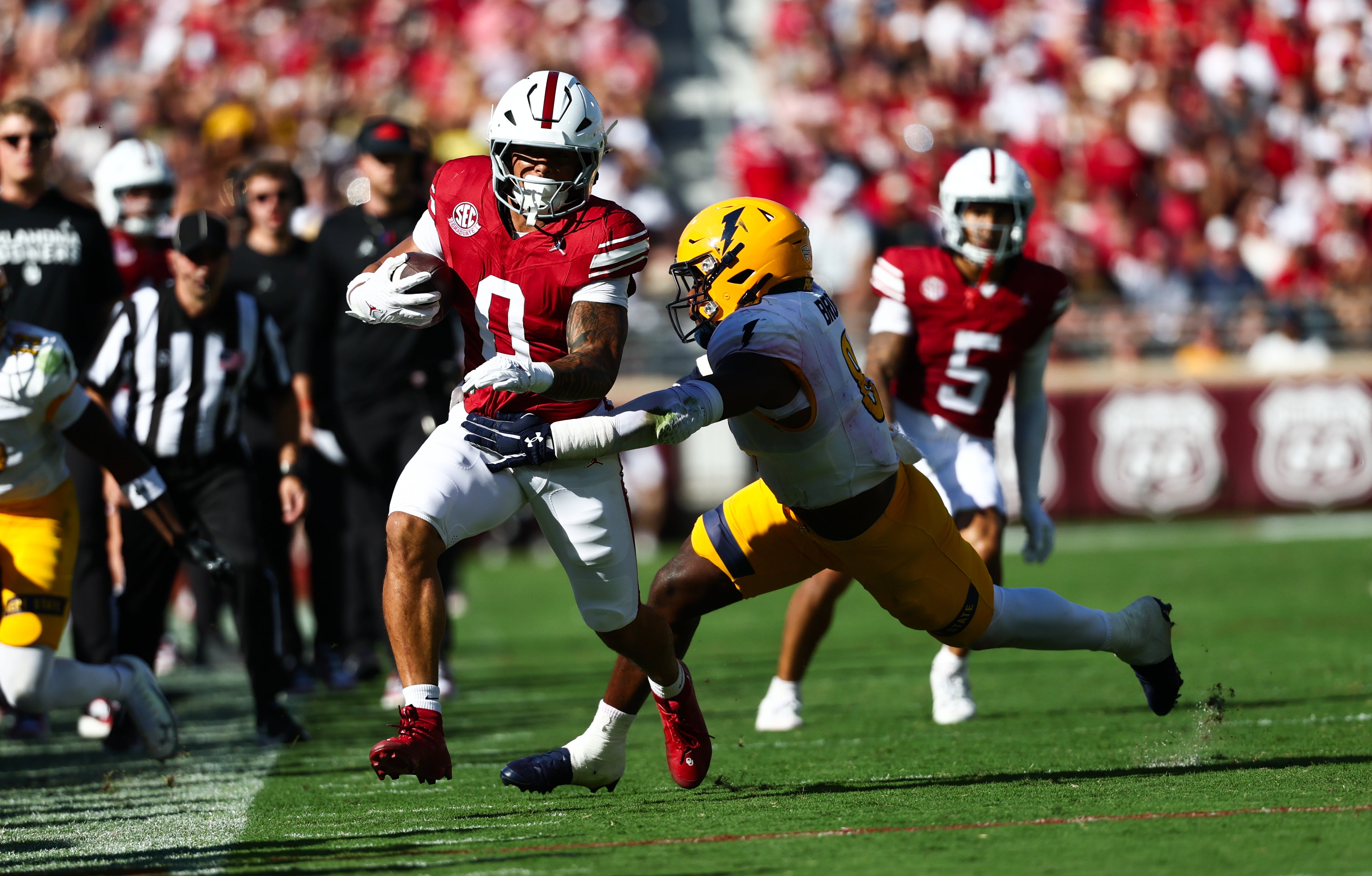 Oct 4, 2025; Norman, Oklahoma, USA; Oklahoma Sooners running back Jaydn Ott (0) runs with the ball as Kent State Golden Flashes linebacker Nylan Brown (8) defends during the second quarter at Gaylord Family-Oklahoma Memorial Stadium.