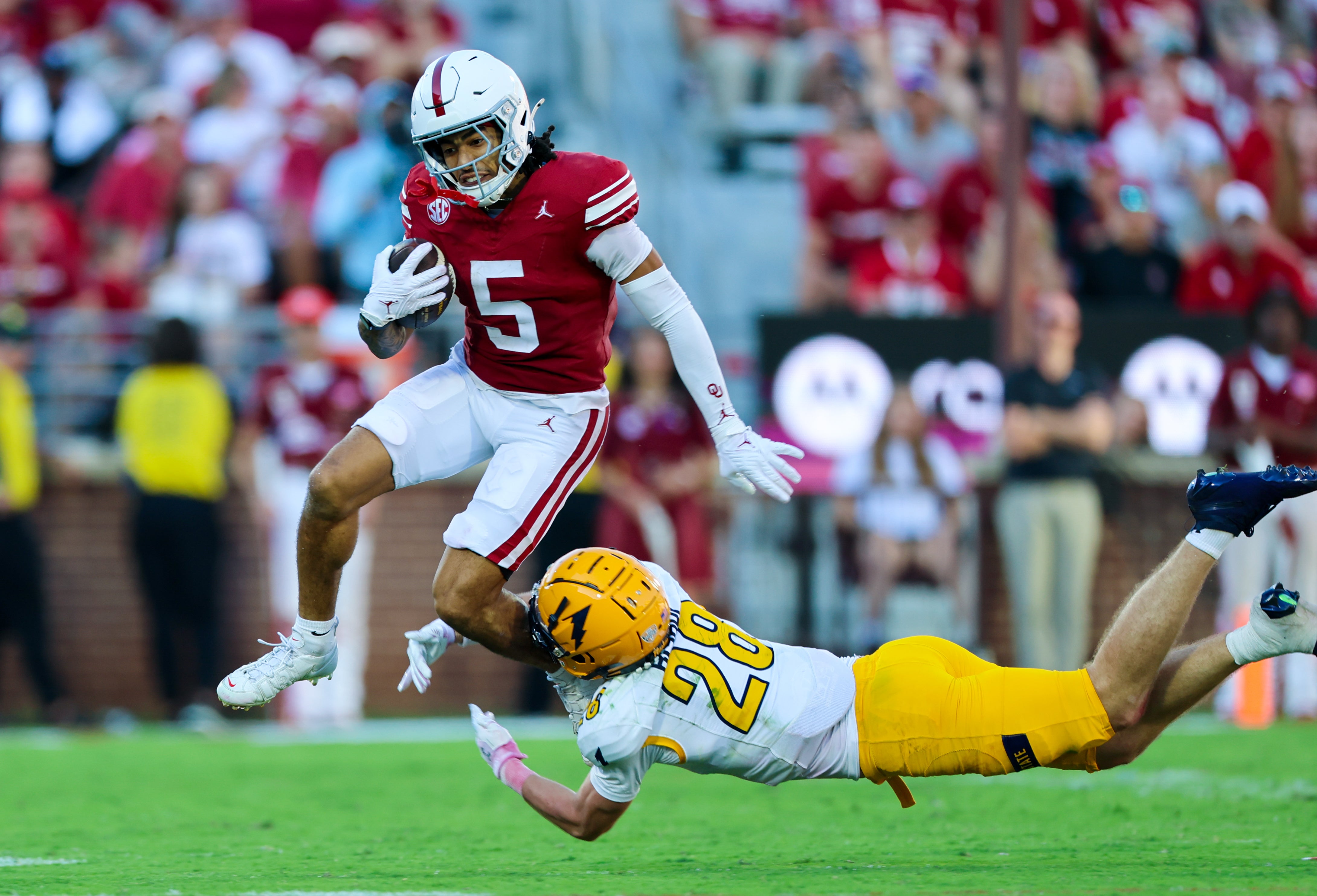 Oct 4, 2025; Norman, Oklahoma, USA; Oklahoma Sooners wide receiver Isaiah Sategna III (5) tries to avoid the tackle of Kent State Golden Flashes safety Brodyn Bishop (28) during the second half at Gaylord Family-Oklahoma Memorial Stadium.