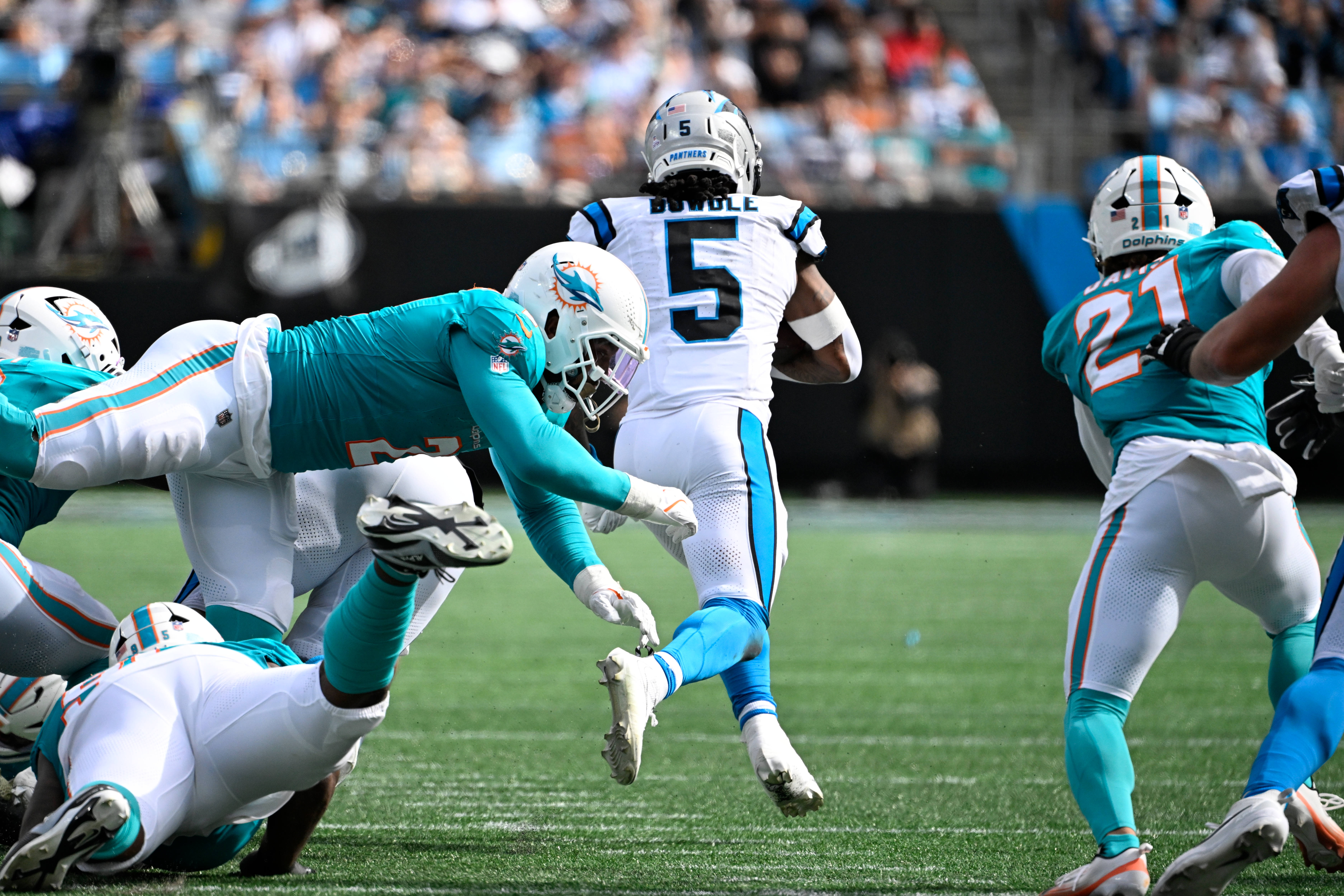 Oct 5, 2025; Charlotte, North Carolina, USA; Carolina Panthers running back Rico Dowdle (5) runs as Miami Dolphins outside linebacker Bradley Chubb (2) and safety Ashtyn Davis (21) defend in the fourth quarter at Bank of America Stadium.