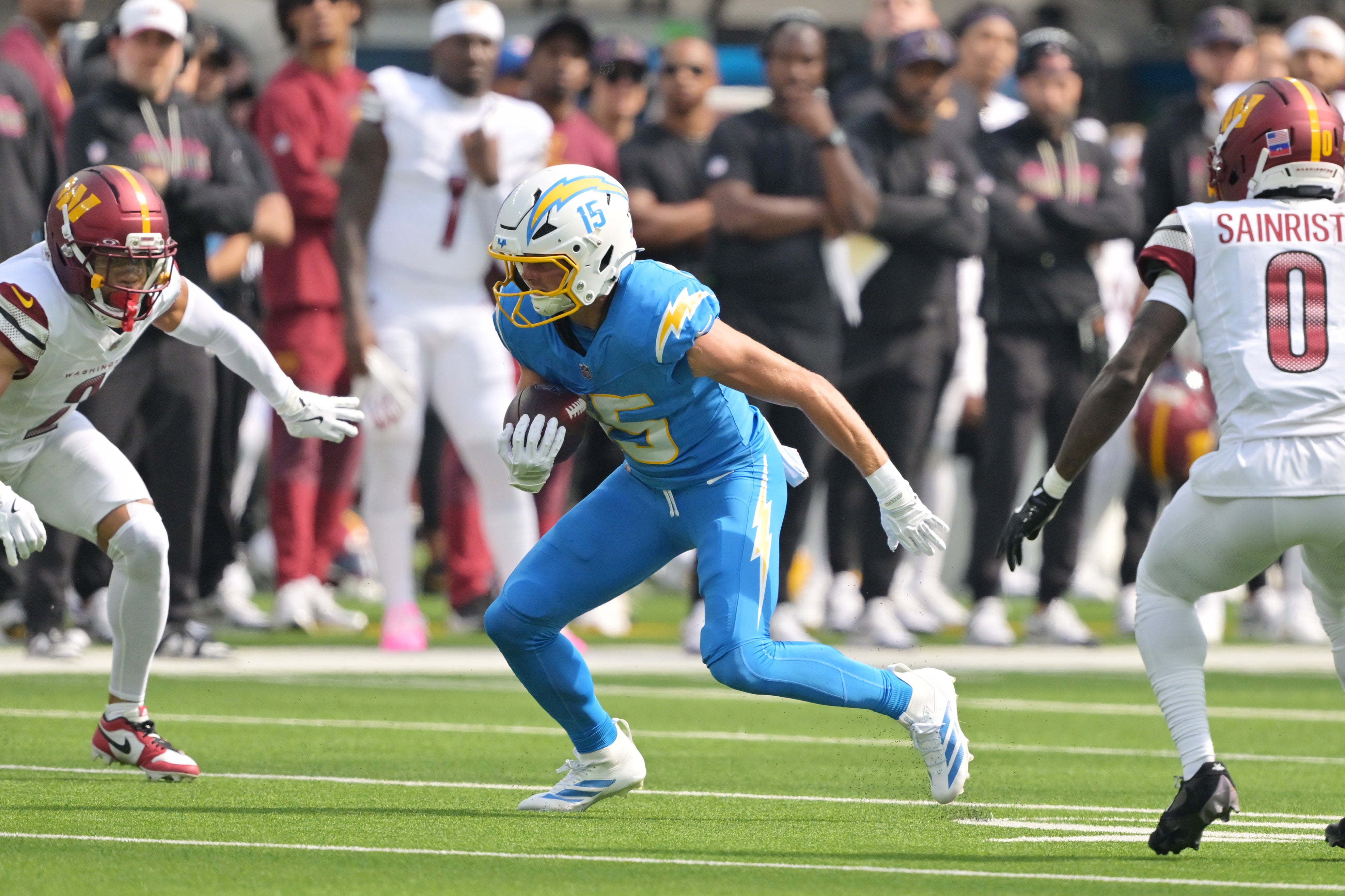 Los Angeles Chargers wide receiver Ladd McConkey (15) runs against Washington Commanders cornerback Marshon Lattimore (2) and cornerback Mike Sainristil (0) in the first half at SoFi Stadium.