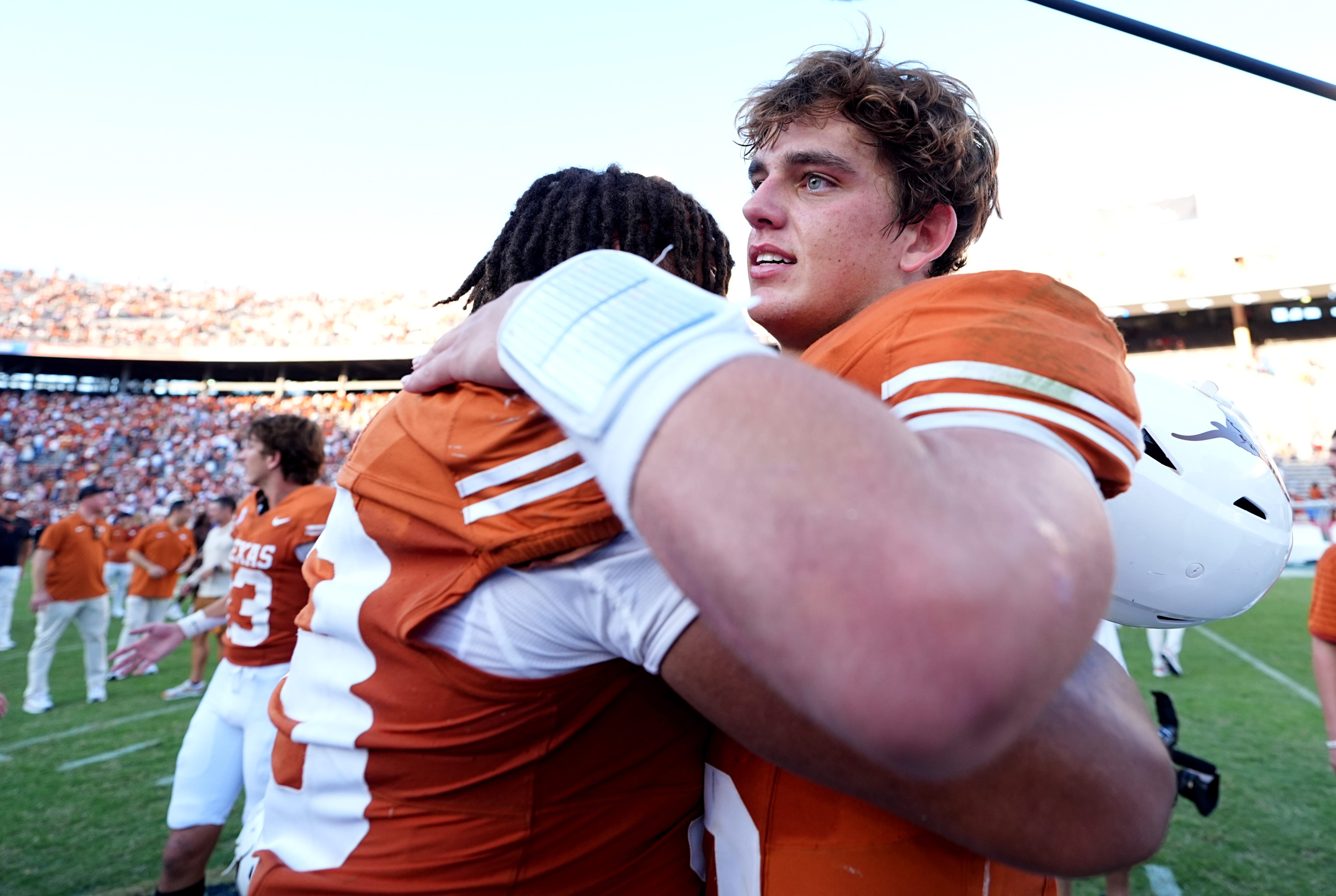 Texas Longhorns quarterback Arch Manning (16) hugs a teammate following the Red River Rivalry college football game between the University of Oklahoma Sooners and the Texas Longhorn at the Cotton Bowl Stadium in Dallas, Texas,