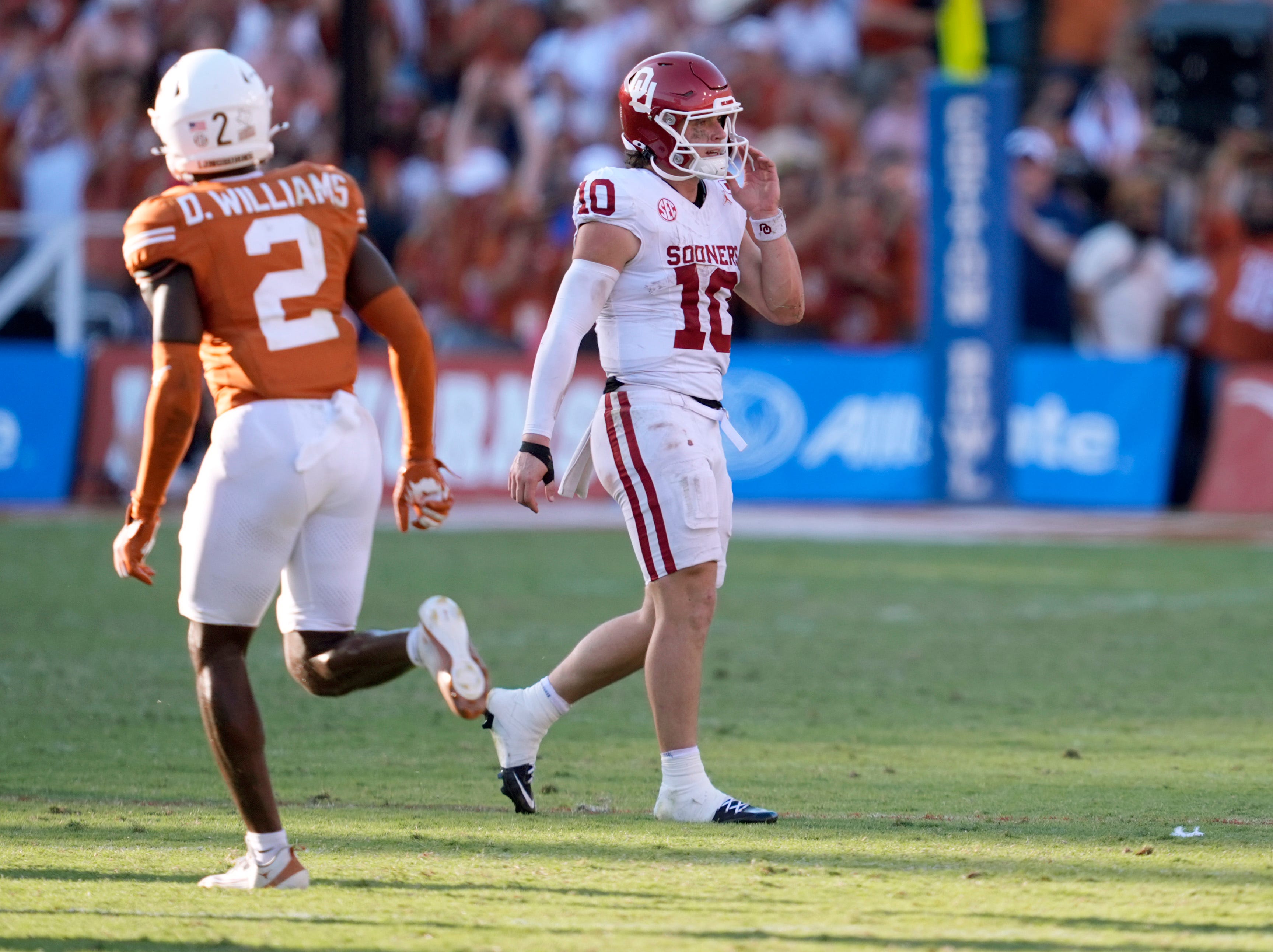 Oklahoma Sooners quarterback John Mateer (10) walks off the field next to Texas Longhorns defensive back Derek Williams Jr. (2) in the second half of the Red River Rivalry college football game between the University of Oklahoma Sooners and the Texas Longhorn at the Cotton Bowl Stadium in Dallas, Texas, Saturday, Oct. 11, 2025.