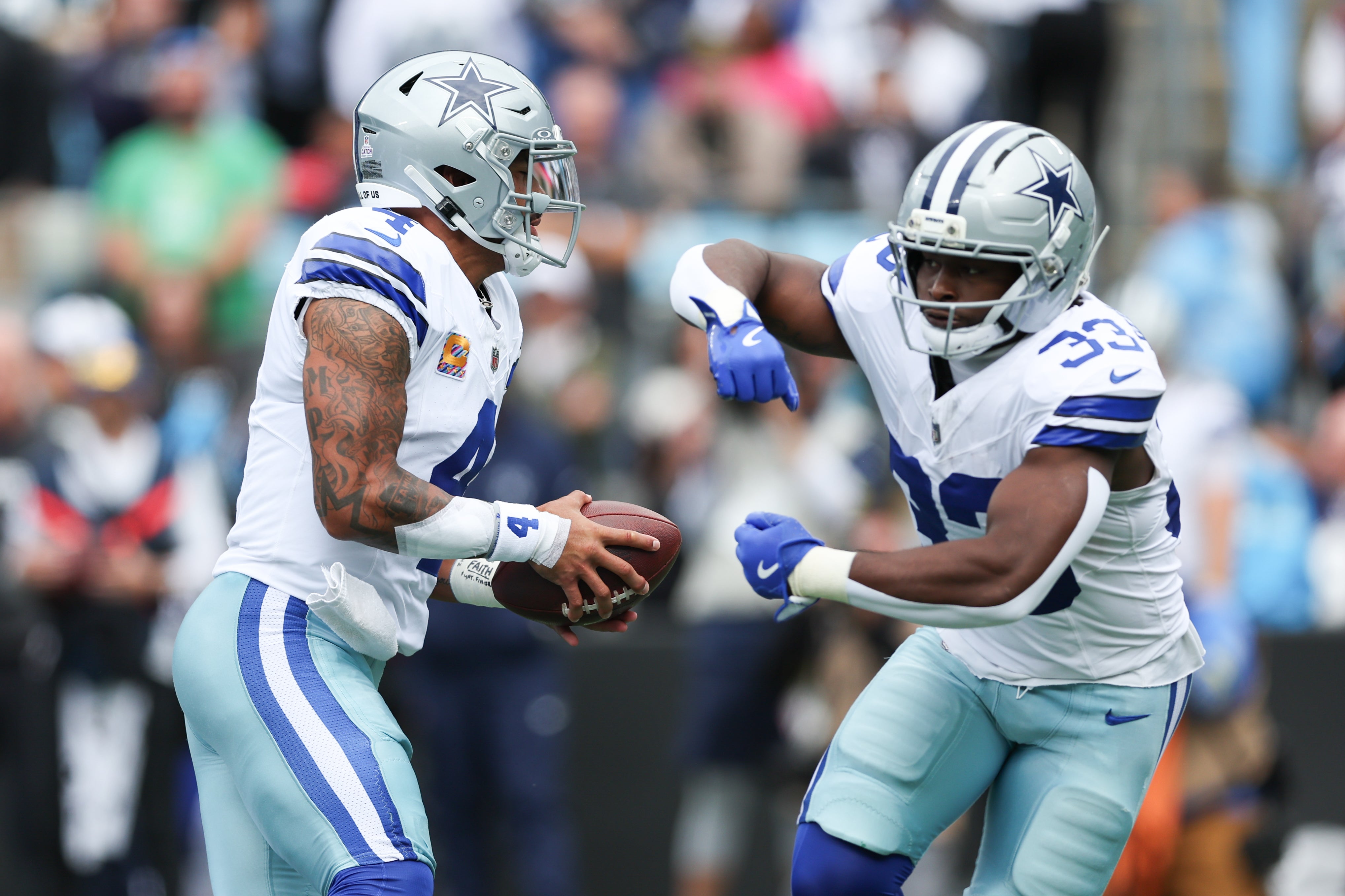 Oct 12, 2025; Charlotte, North Carolina, USA; Dallas Cowboys quarterback Dak Prescott (4) hands the ball to running back Javonte Williams (33) during the first quarter against the Carolina Panthers at Bank of America Stadium.