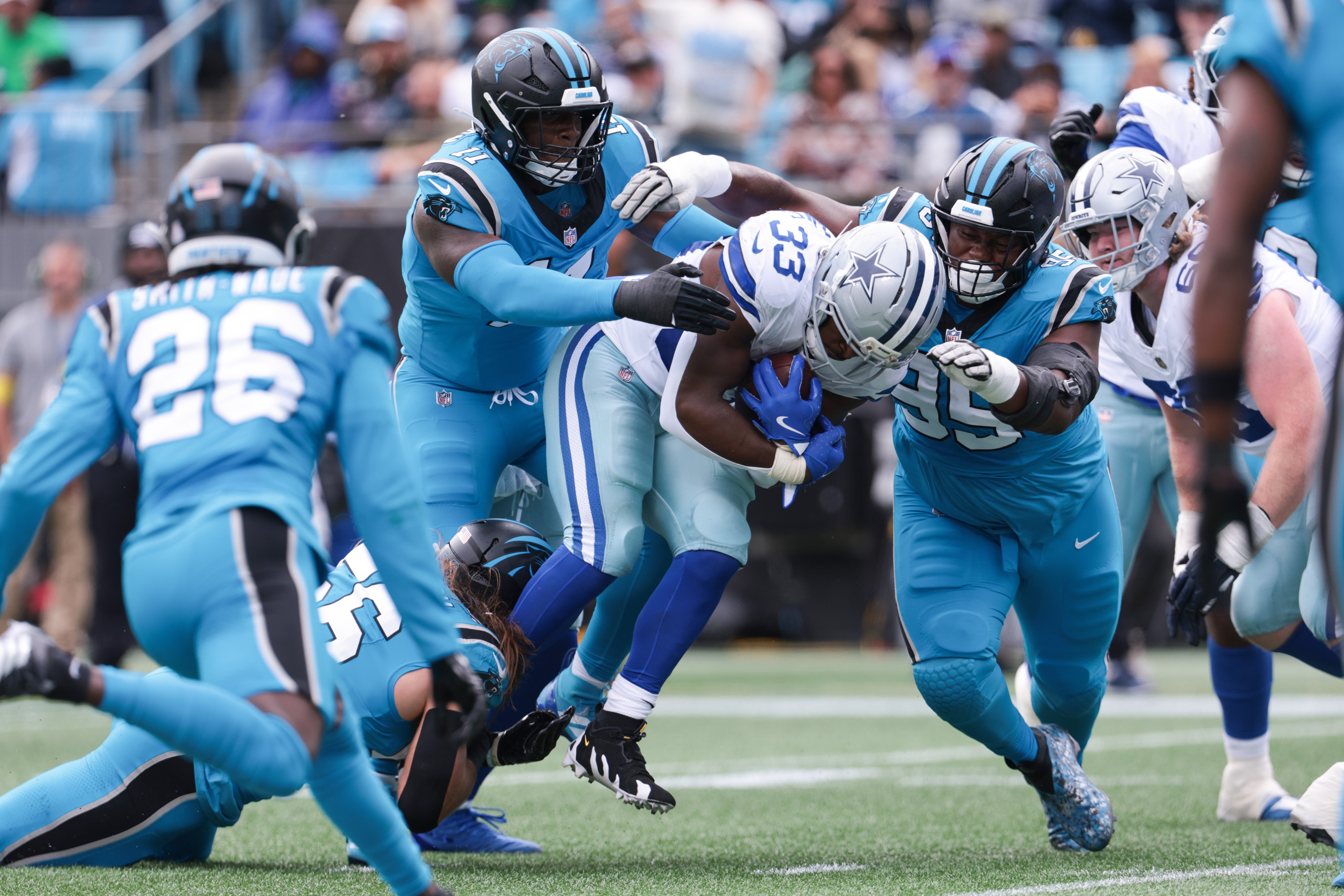 Oct 12, 2025; Charlotte, North Carolina, USA; Carolina Panthers linebacker Nic Scourton (11) and defensive end Derrick Brown (95) tackle Dallas Cowboys running back Javonte Williams (33) short of the goal line during the first quarter at Bank of America Stadium.