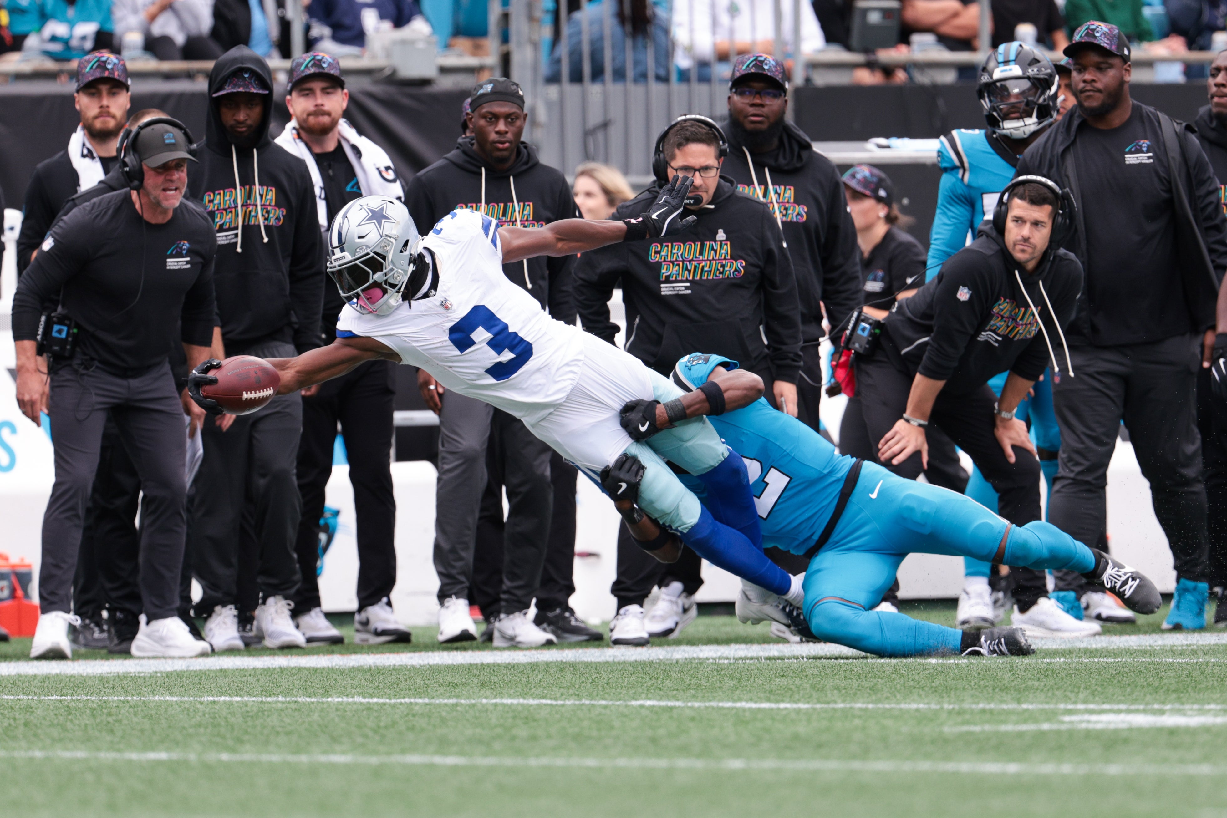 Oct 12, 2025; Charlotte, North Carolina, USA; Dallas Cowboys wide receiver George Pickens (3) reaches while Carolina Panthers cornerback Mike Jackson (2) tackles during the second half at Bank of America Stadium.