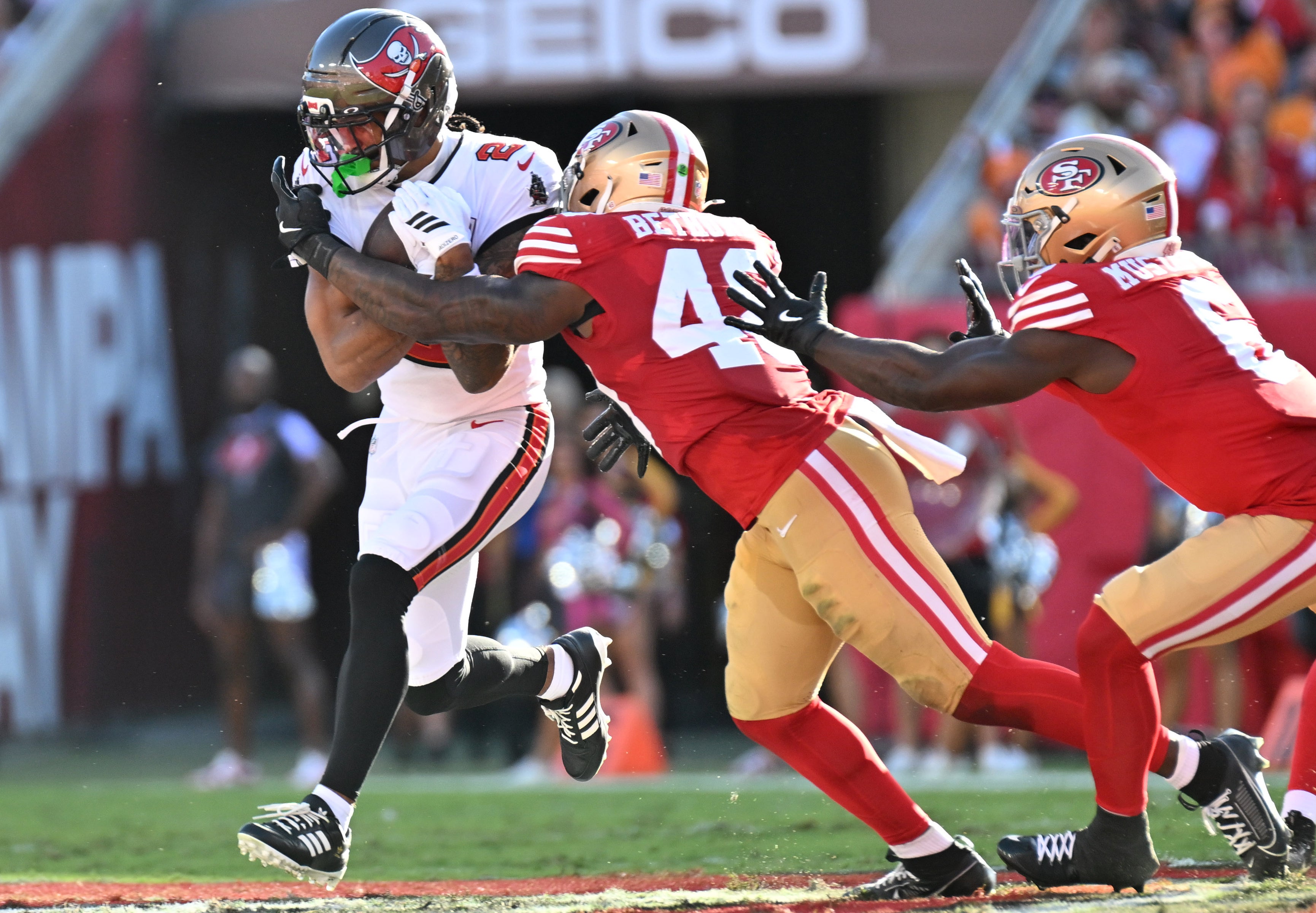 Oct 12, 2025; Tampa, Florida, USA: Tampa Bay Buccaneers wide receiver Emeka Egbuka (2) runs for a gain past San Francisco 49ers linebacker Tatum Bethune (48) during the second quarter at Raymond James Stadium.
