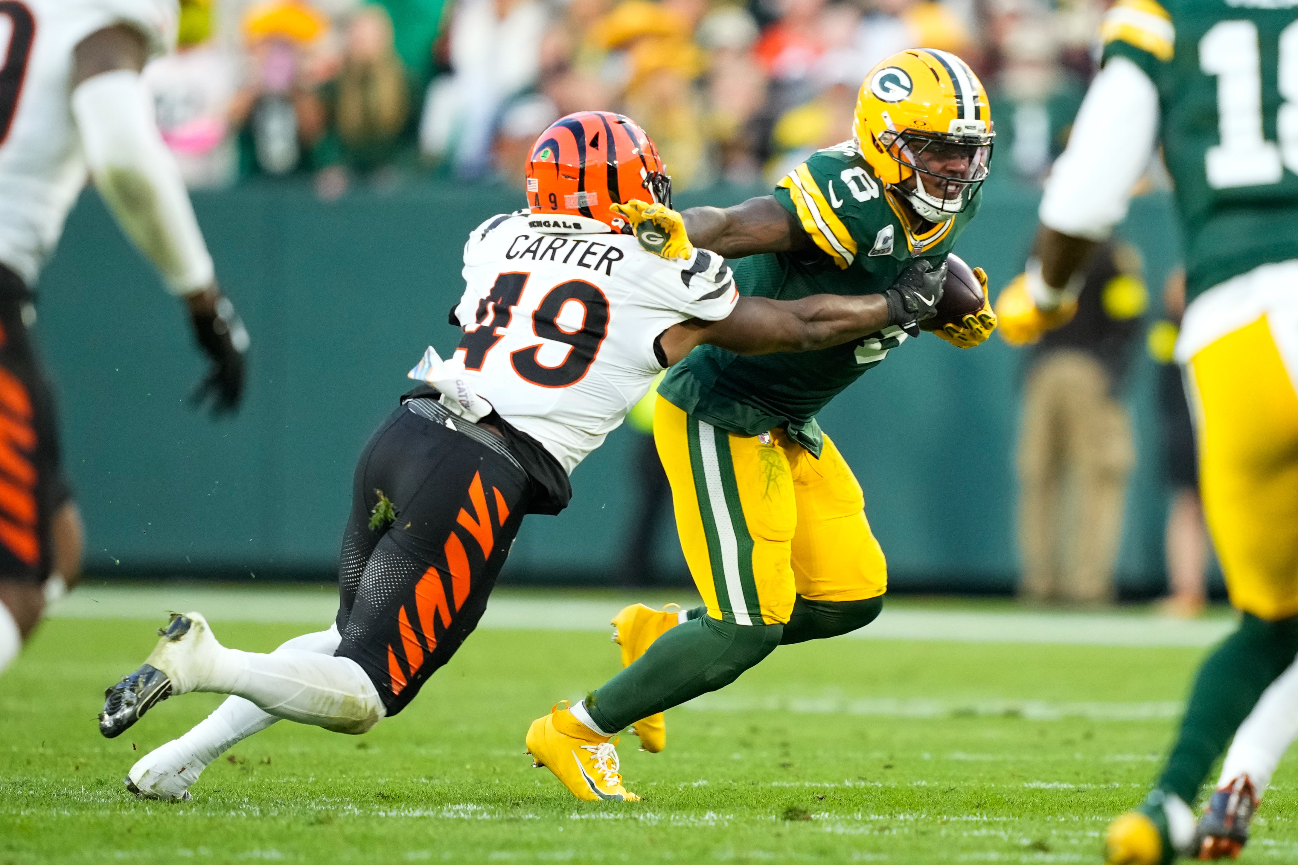 Oct 12, 2025; Green Bay, Wisconsin, USA; Green Bay Packers running back Josh Jacobs (8) runs the ball against Cincinnati Bengals linebacker Barrett Carter (49) in the second half at Lambeau Field.