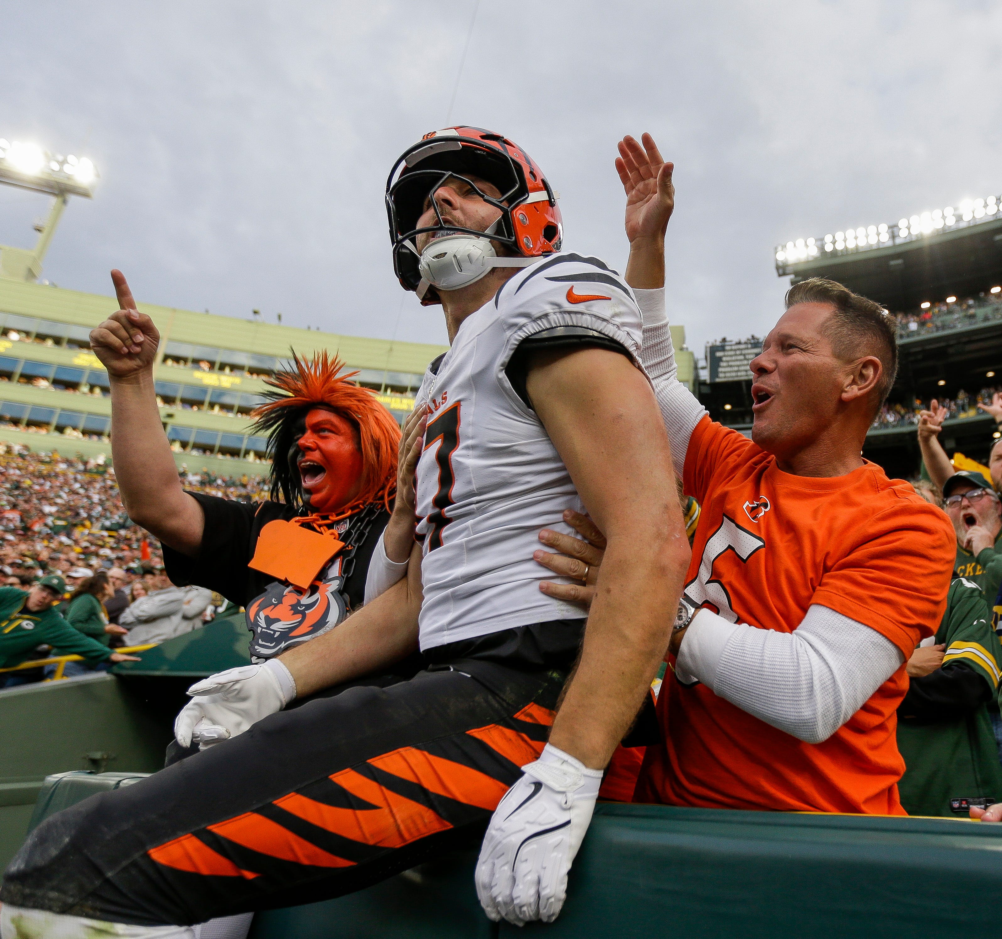 Cincinnati Bengals tight end Tanner Hudson (87) leaps into the stands to celebrate with fans after scoring a touchdown against the Green Bay Packers on Sunday, October 12, 2025, at Lambeau Field in Green Bay, Wis. The Packers won the game, 27-18.
